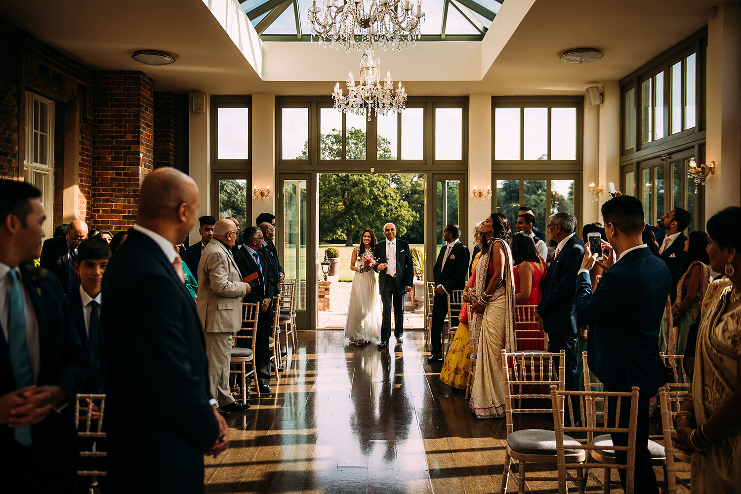  bride and her father enter wedding ceremony in the conservatory 