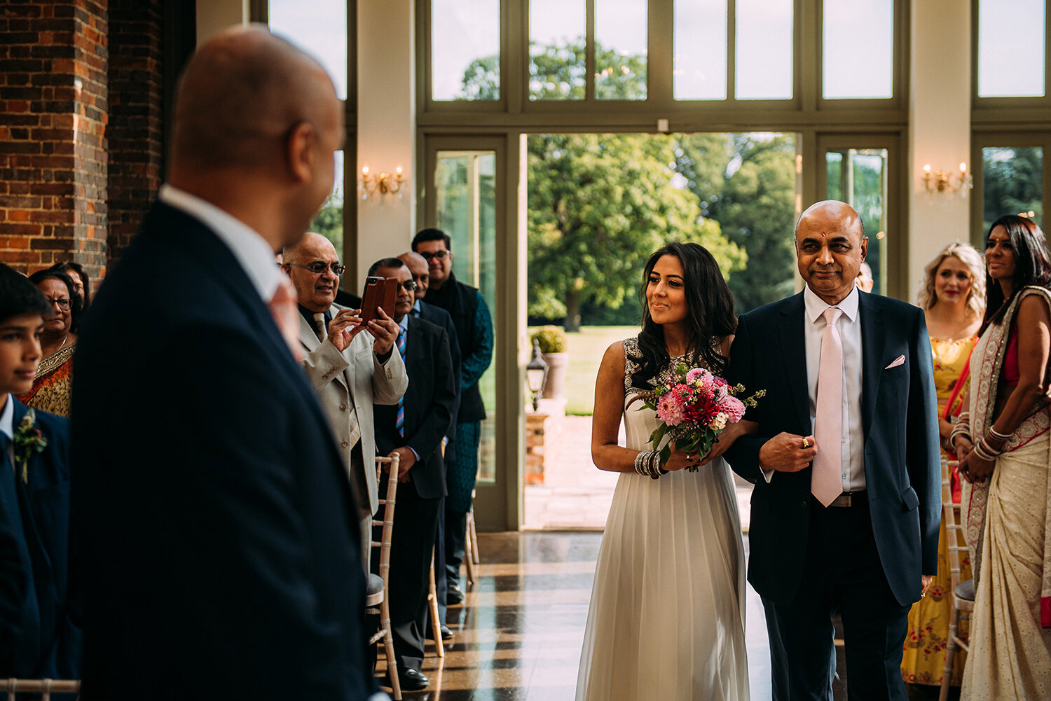  bride and her father enter wedding ceremony in the conservatory 