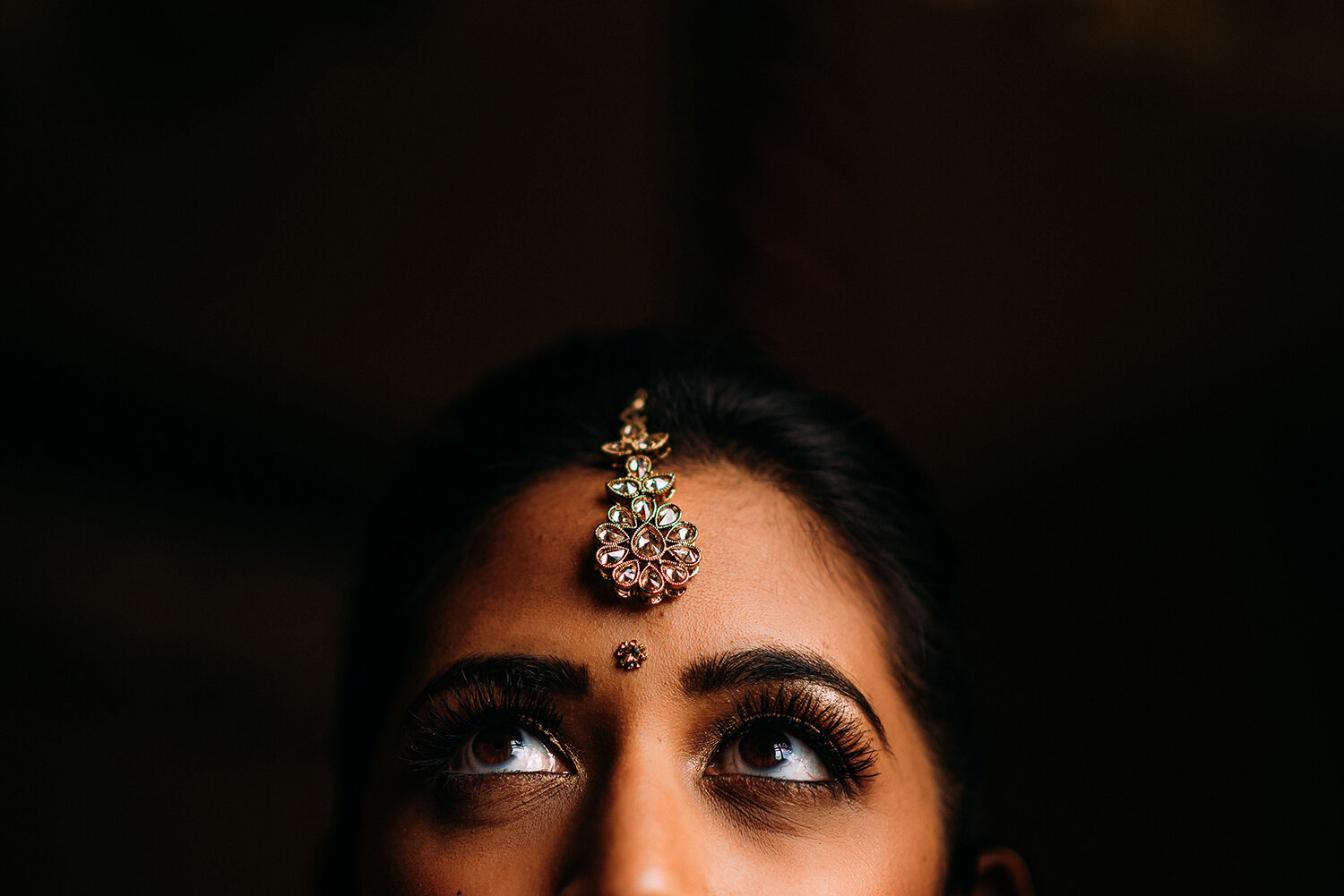  close up of brides eyes and traditional Indian head wear 