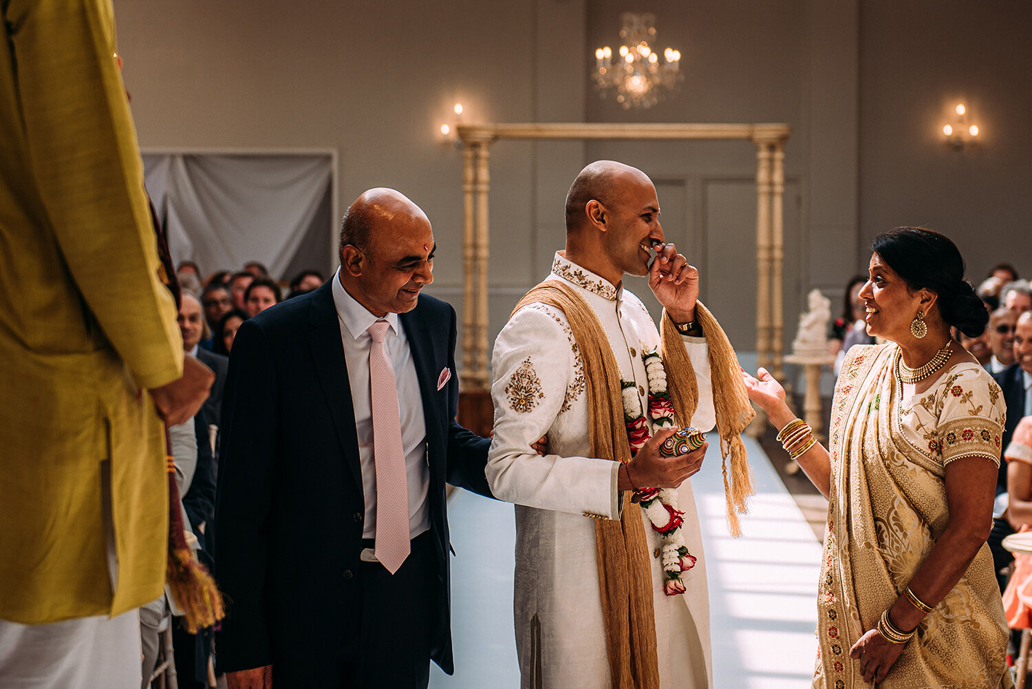  brides mother and father joke with the groom before the ceremony starts 