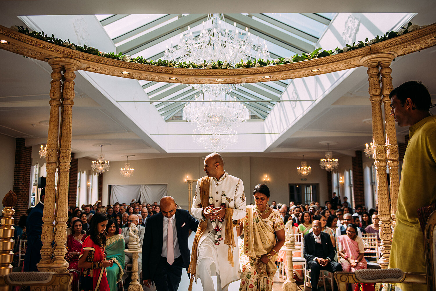  groom and brides mother and father step up onto the mandap 