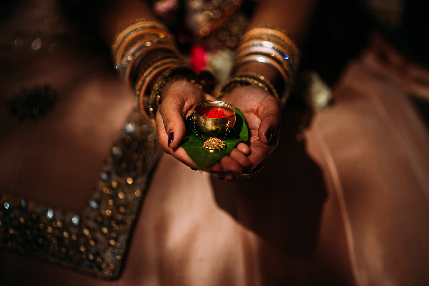  bride holds sindoor, a pot of red powder in nice light 