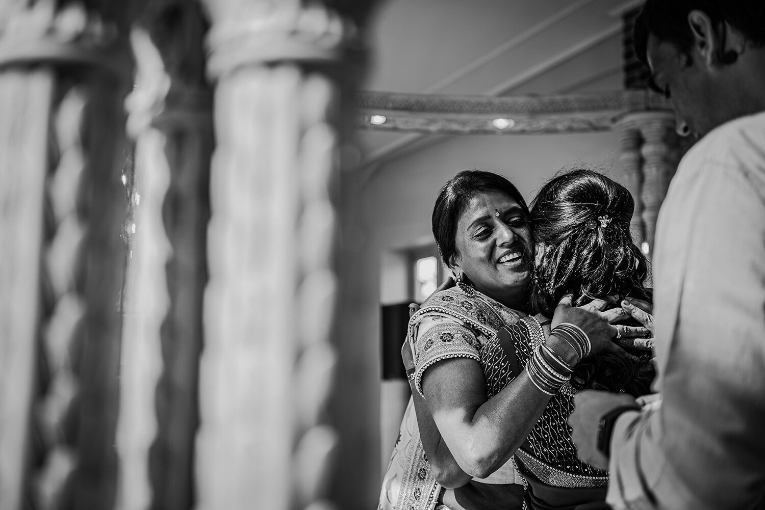  bw photo, huge smile on brides mother face as she gives her daughter a big hug 