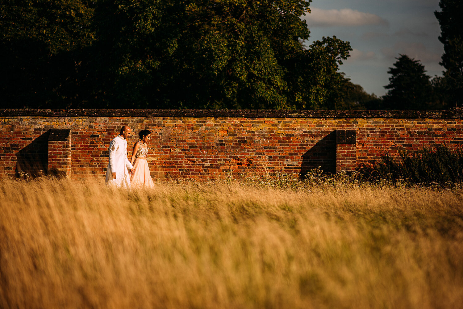  bride and groom walking along the walled gardens 