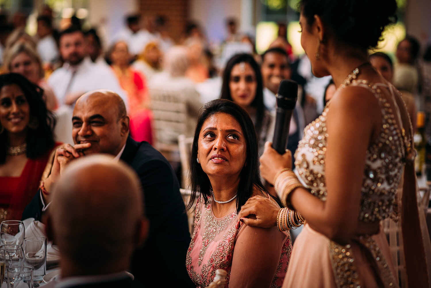  bride’s mum looks lovingly at her daughter as she thanks the room 
