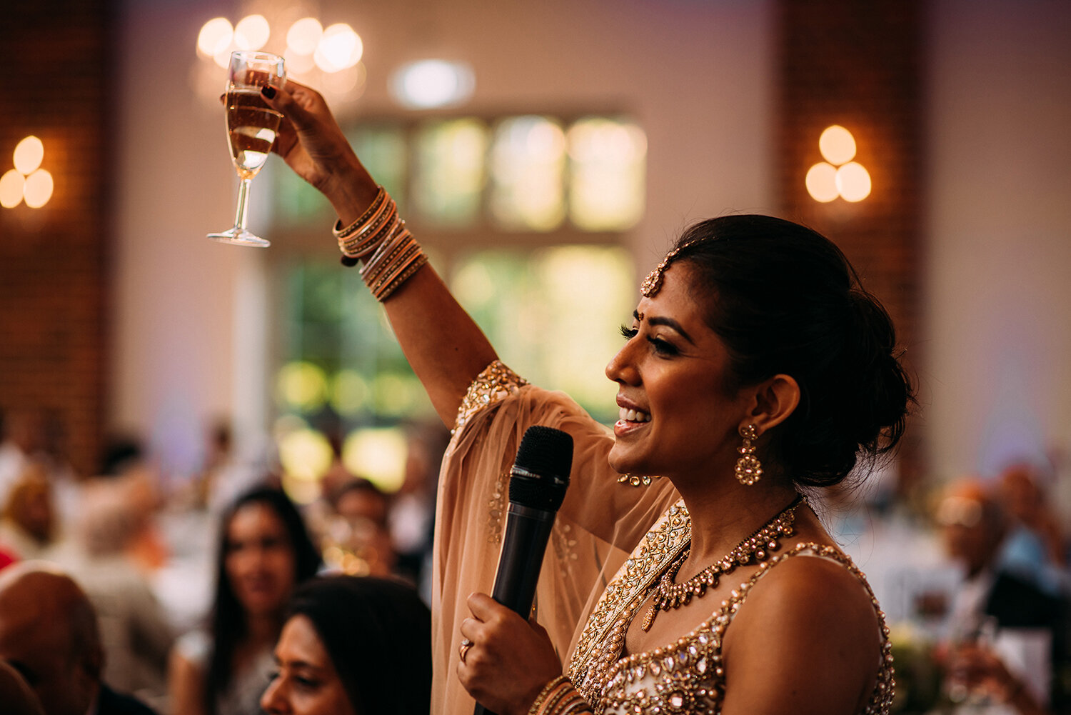 bride lifts a glass as she toasts the room 
