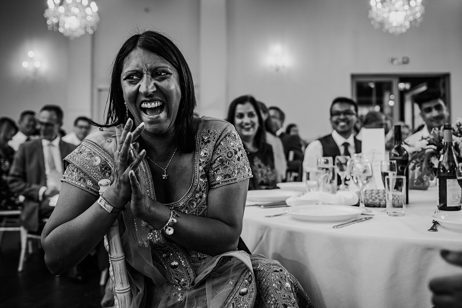  bw photo of the guests laughing during the speeches 