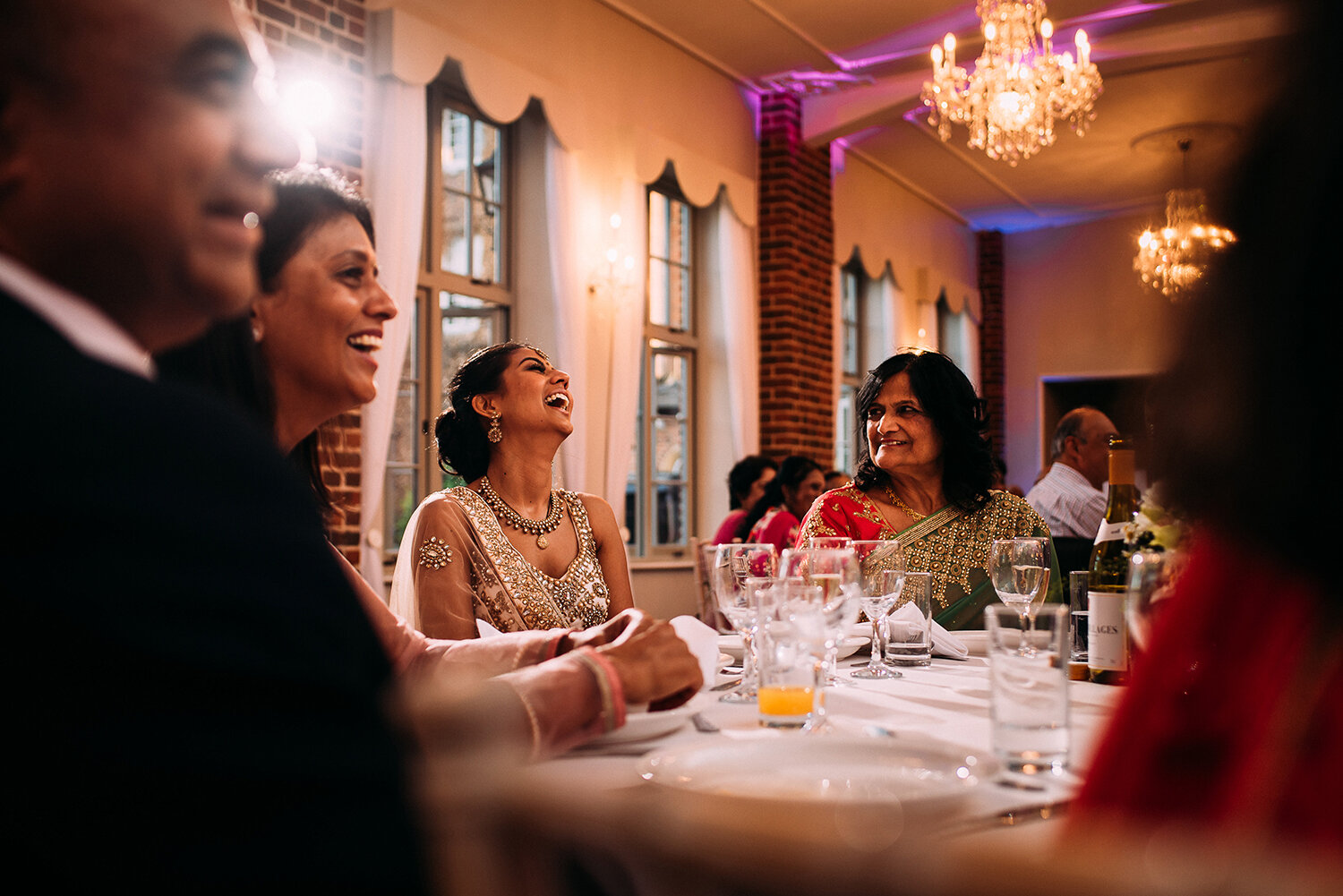  bride and her family laugh during the grooms speech 