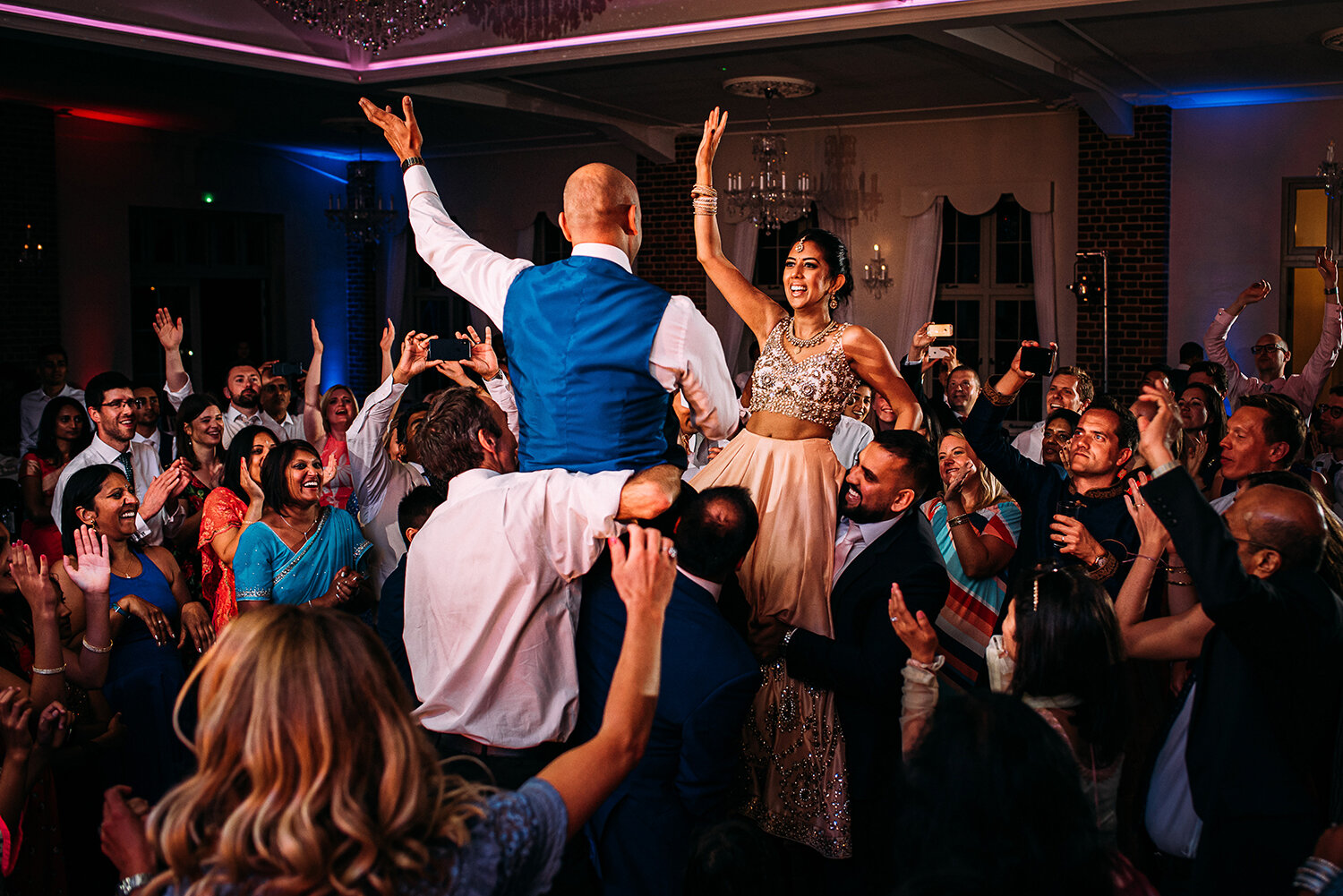  bride and groom lifted up on the dance floor 
