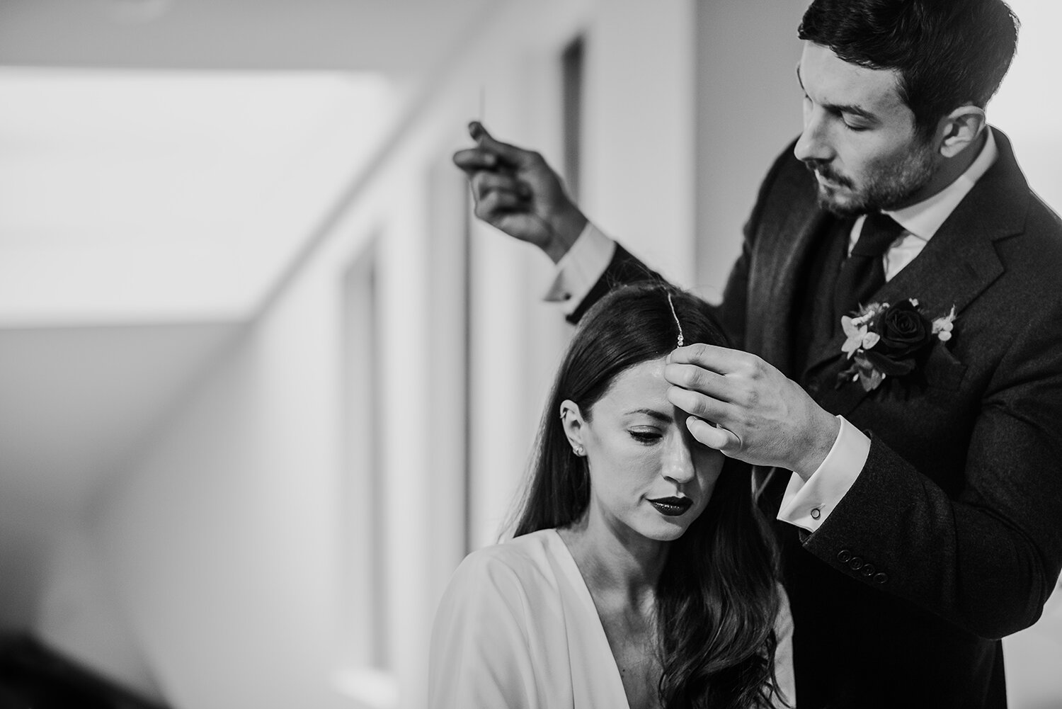  bw photo of groom doing the brides hair 