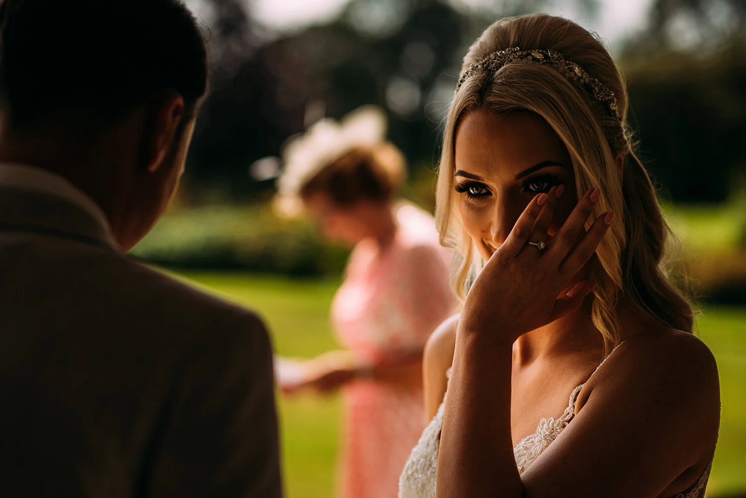 bride wipes a tear during her gran’s reading at the outdoor service
