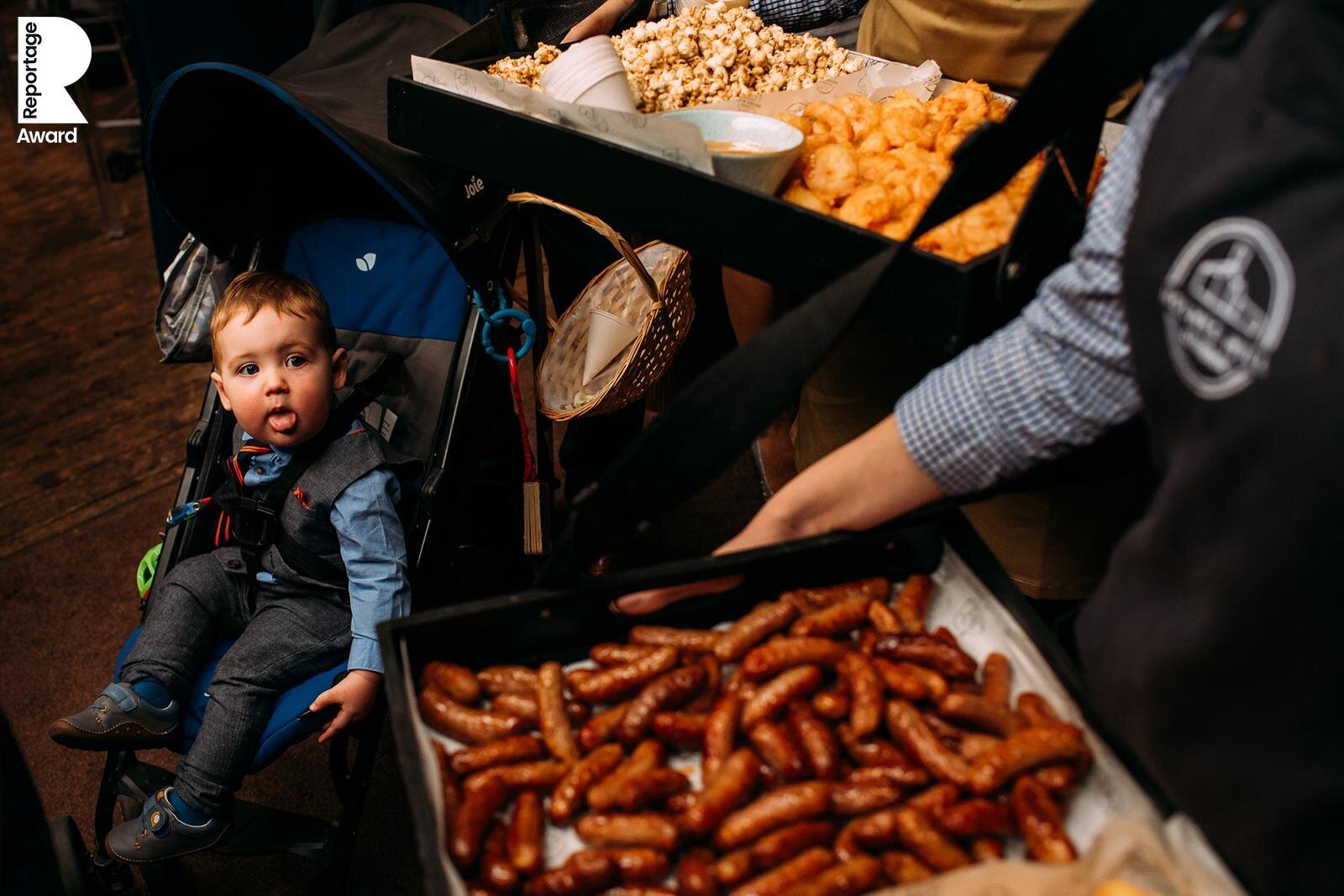  boy looking at a tray of sausages 