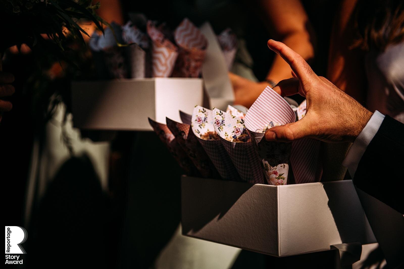  close up of hands picking up cones of confetti 