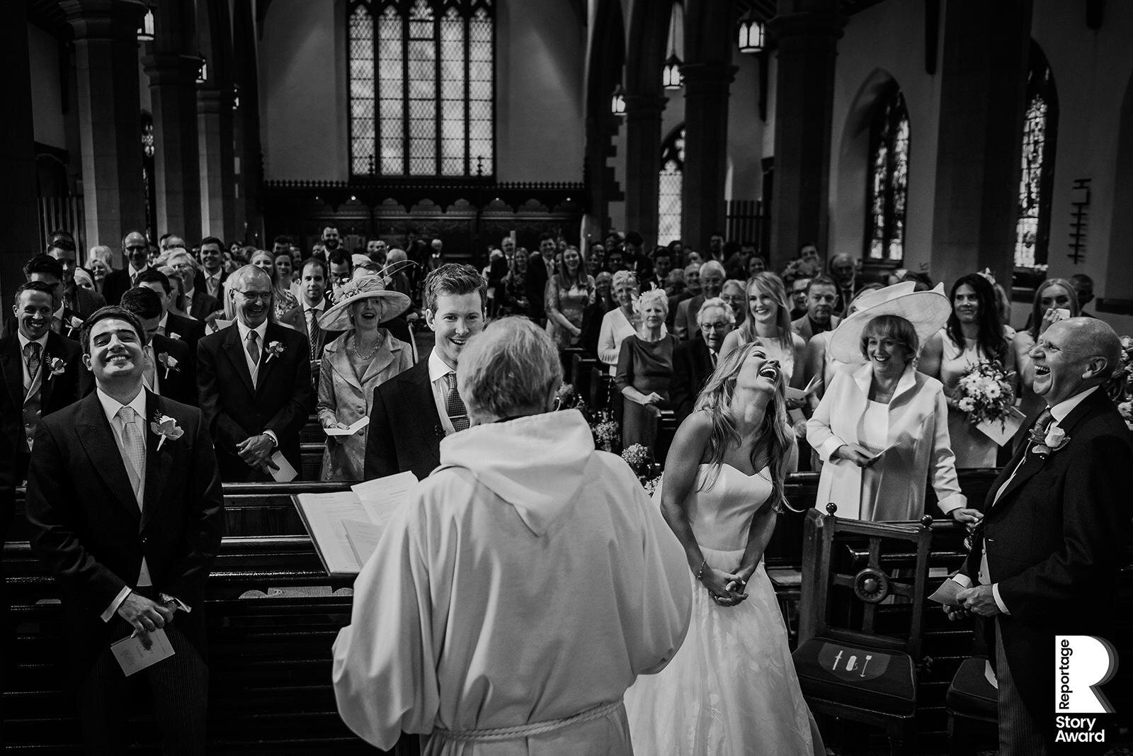 Bride, groom and guests laughing in church 