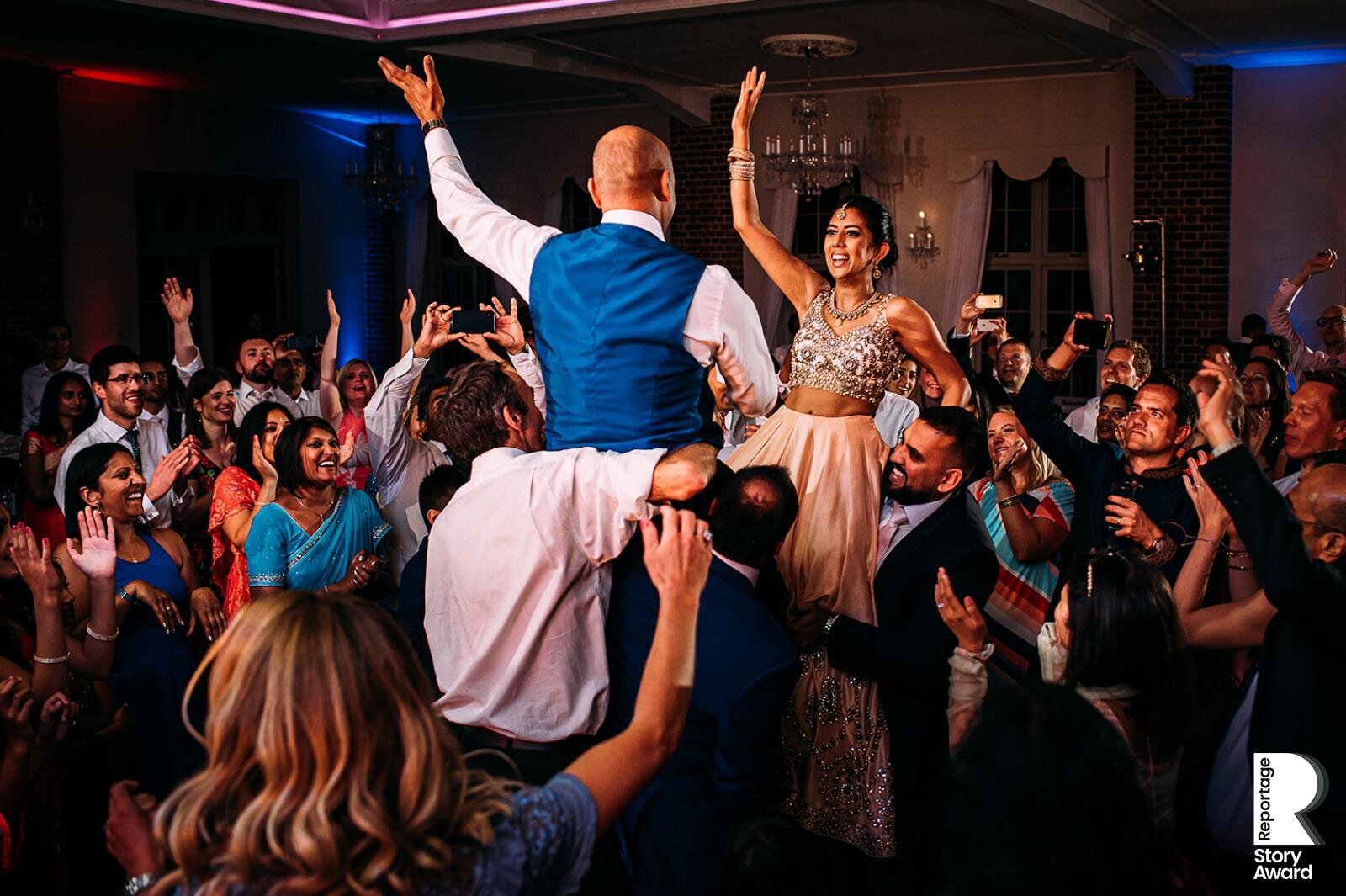  Bride and groom lifted in the air on a busy dance floor. 