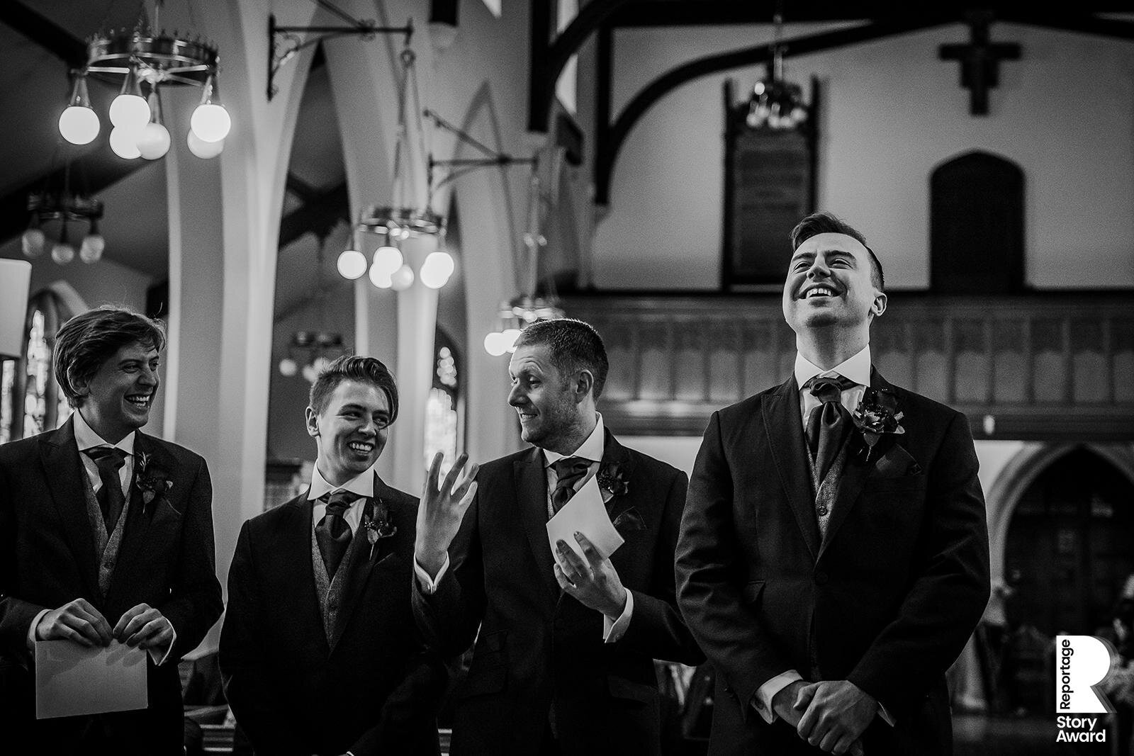  Groom waits at alter while his friends joke behind him 