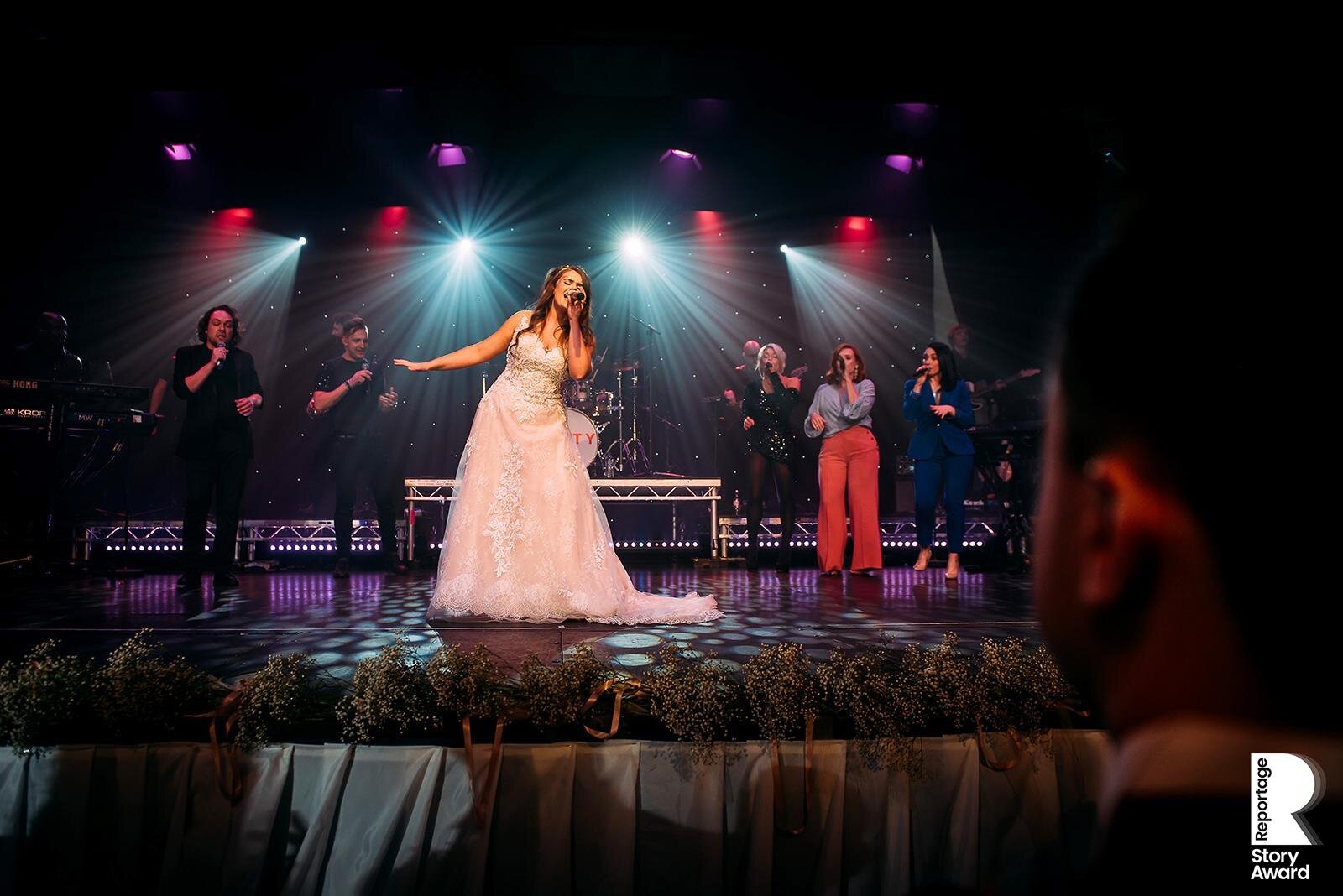  Bride on stage singing a song to her husband 