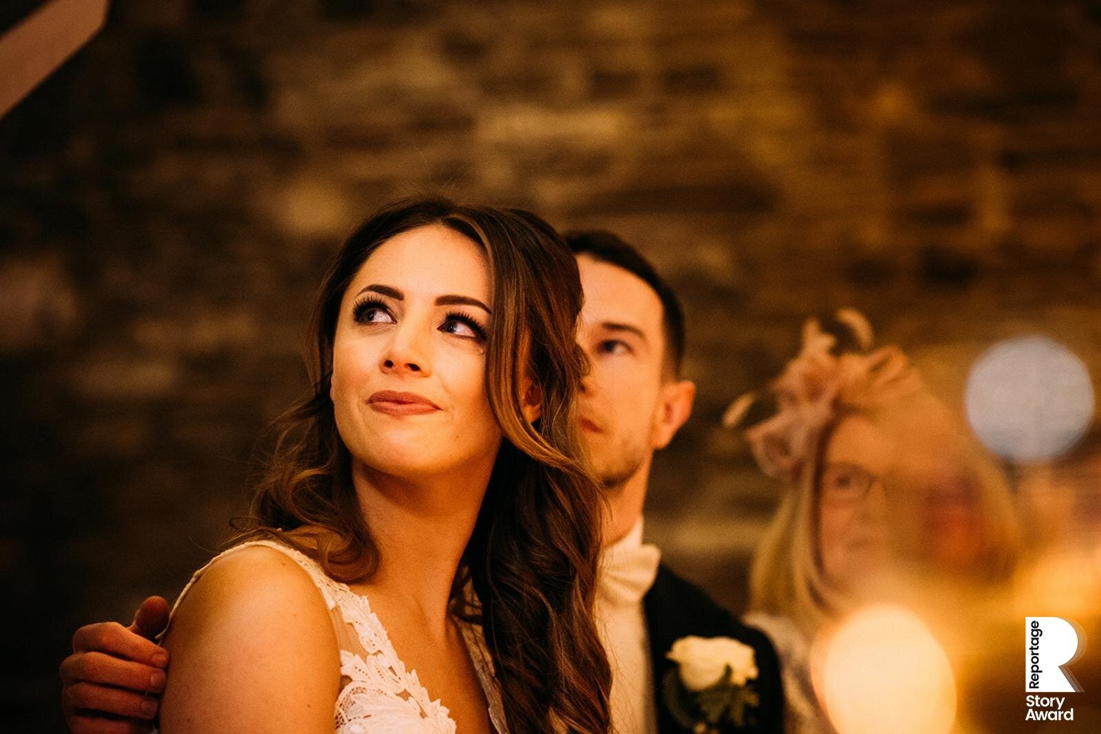  emotional bride looks up at her father during his speech. 