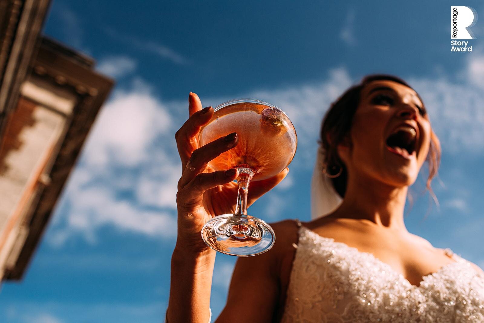  Excited bride, close up of cocktail which contrasts with the blue sky. 