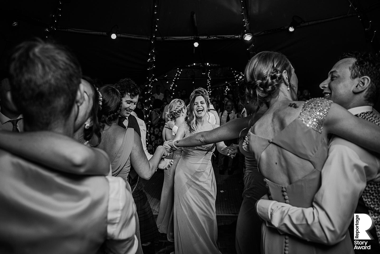  Full dance floor focussing on one of the bridesmaids laughing. 