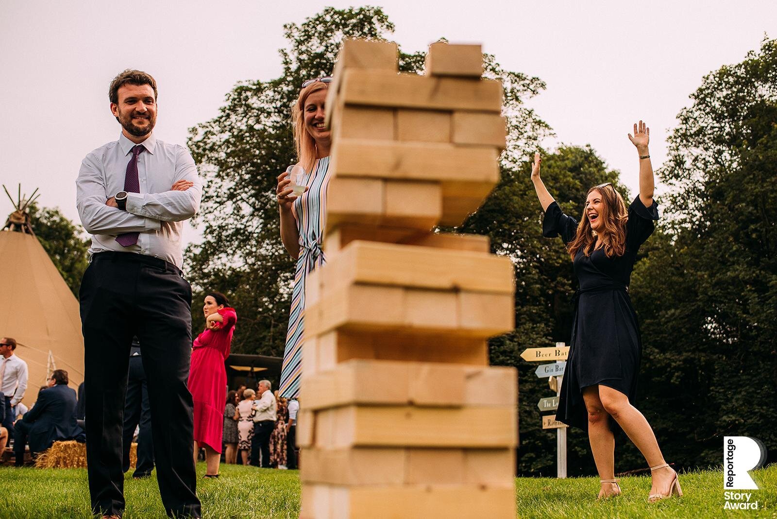  Guest celebrates not toppling the Jenga tower. 