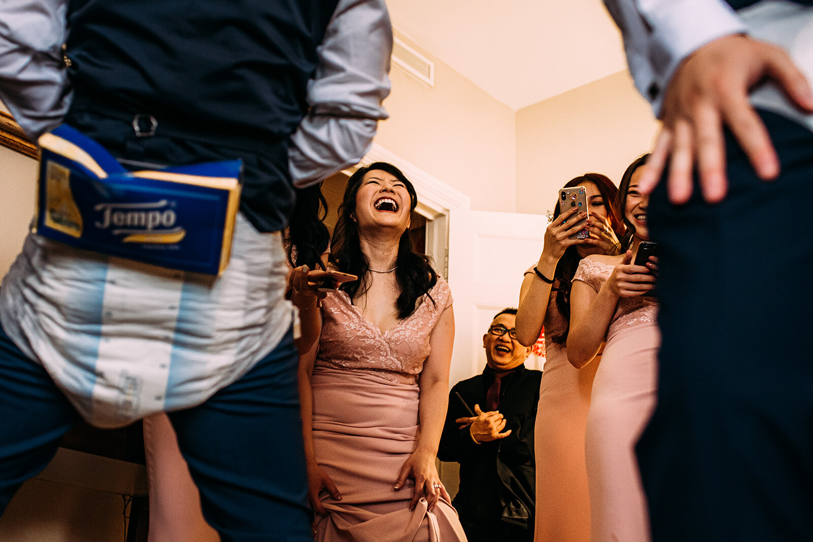 Bridesmaids and groomsmen laughing during traditional door games.