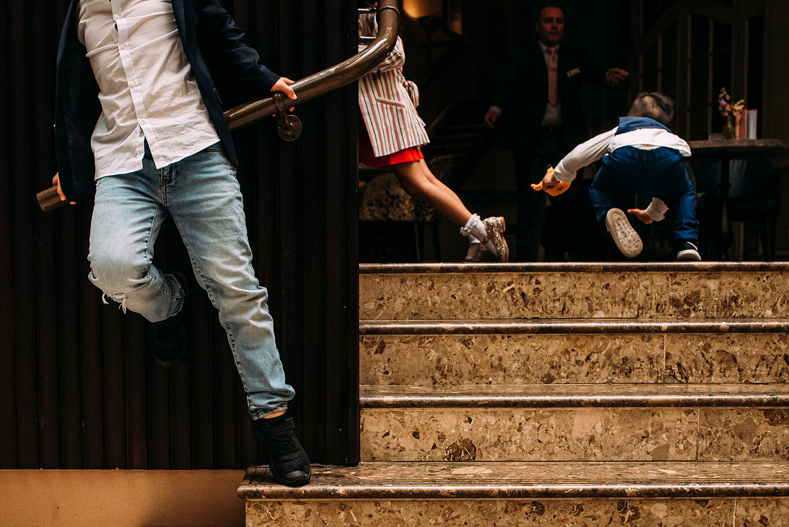interesting composition of kids playing at a wedding.