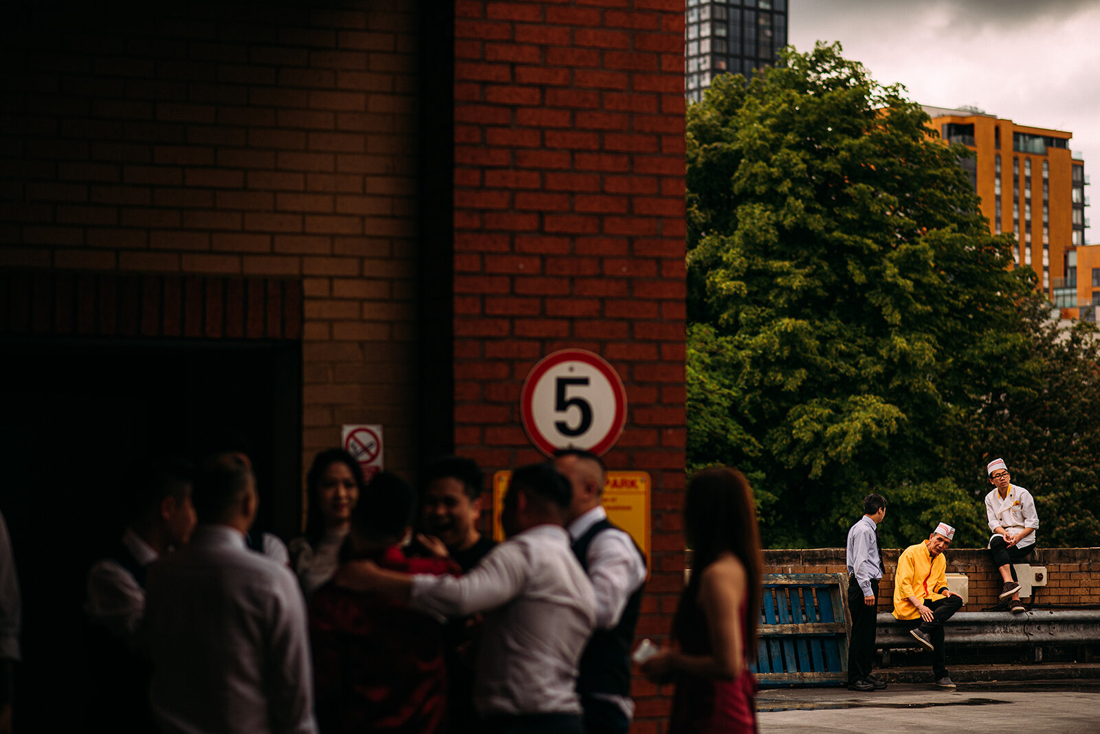 Chefs having a smoke outside the Glamorous Chinese restaurant with guests laughing in the foreground