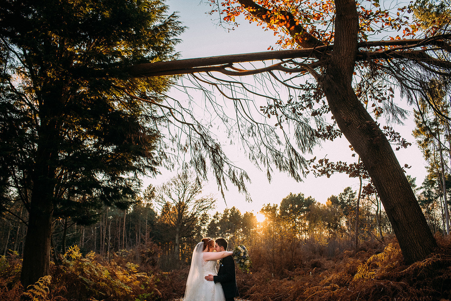  Bride and groom in the woods as the sun goes down 