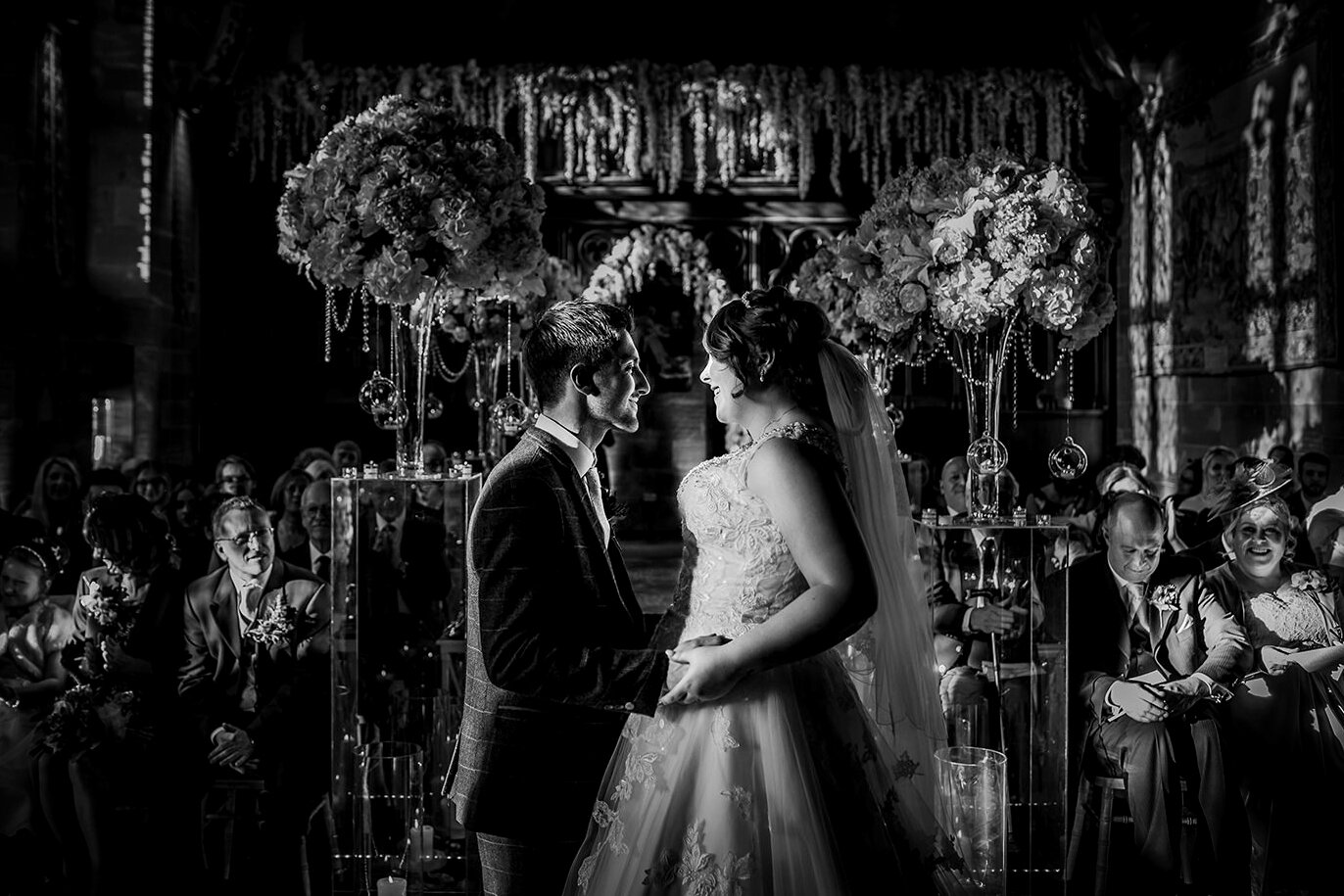  BW photo. Bride and groom saying vows in the great hall. 
