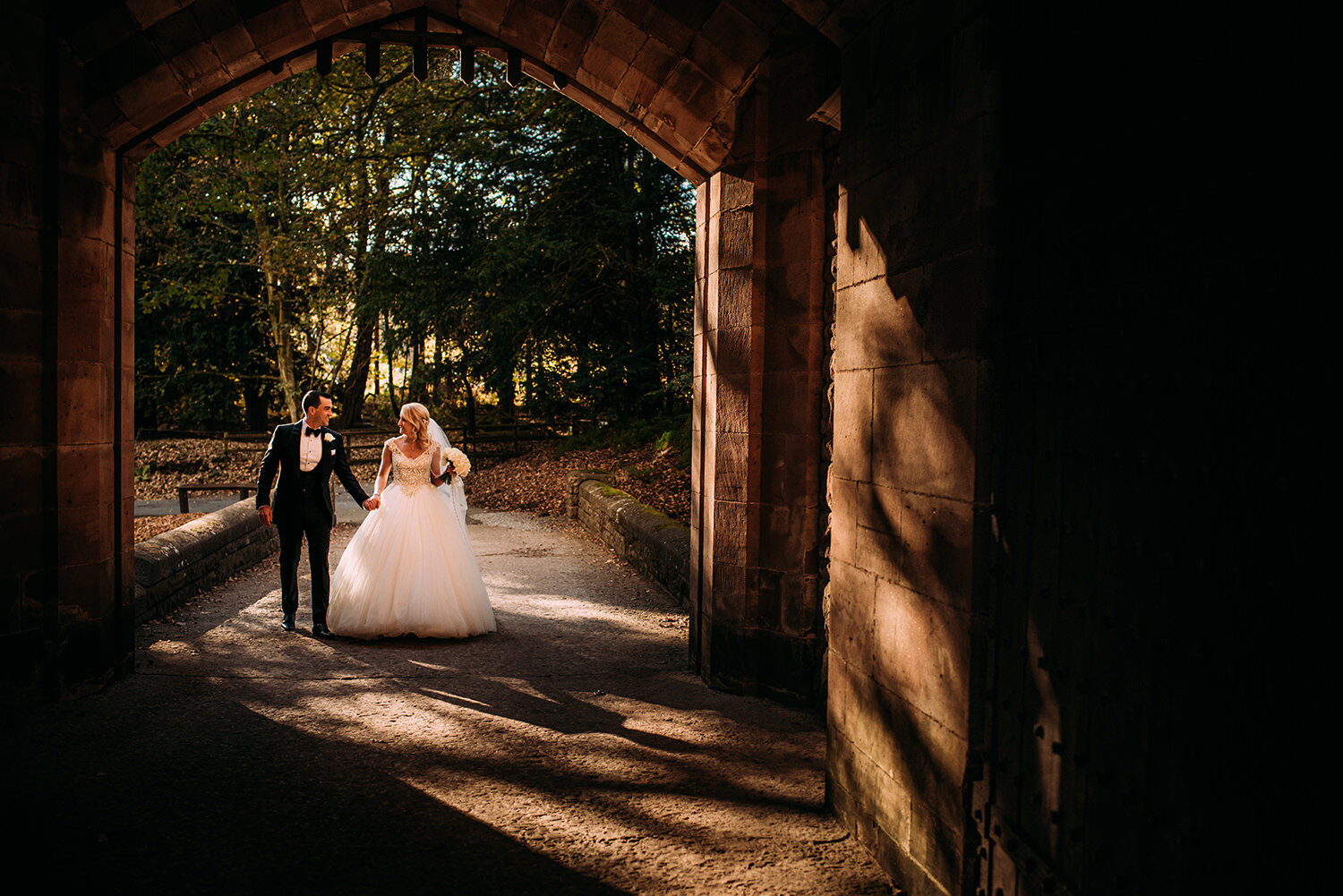  bride and groom walking the gate at Peckforton Castle 