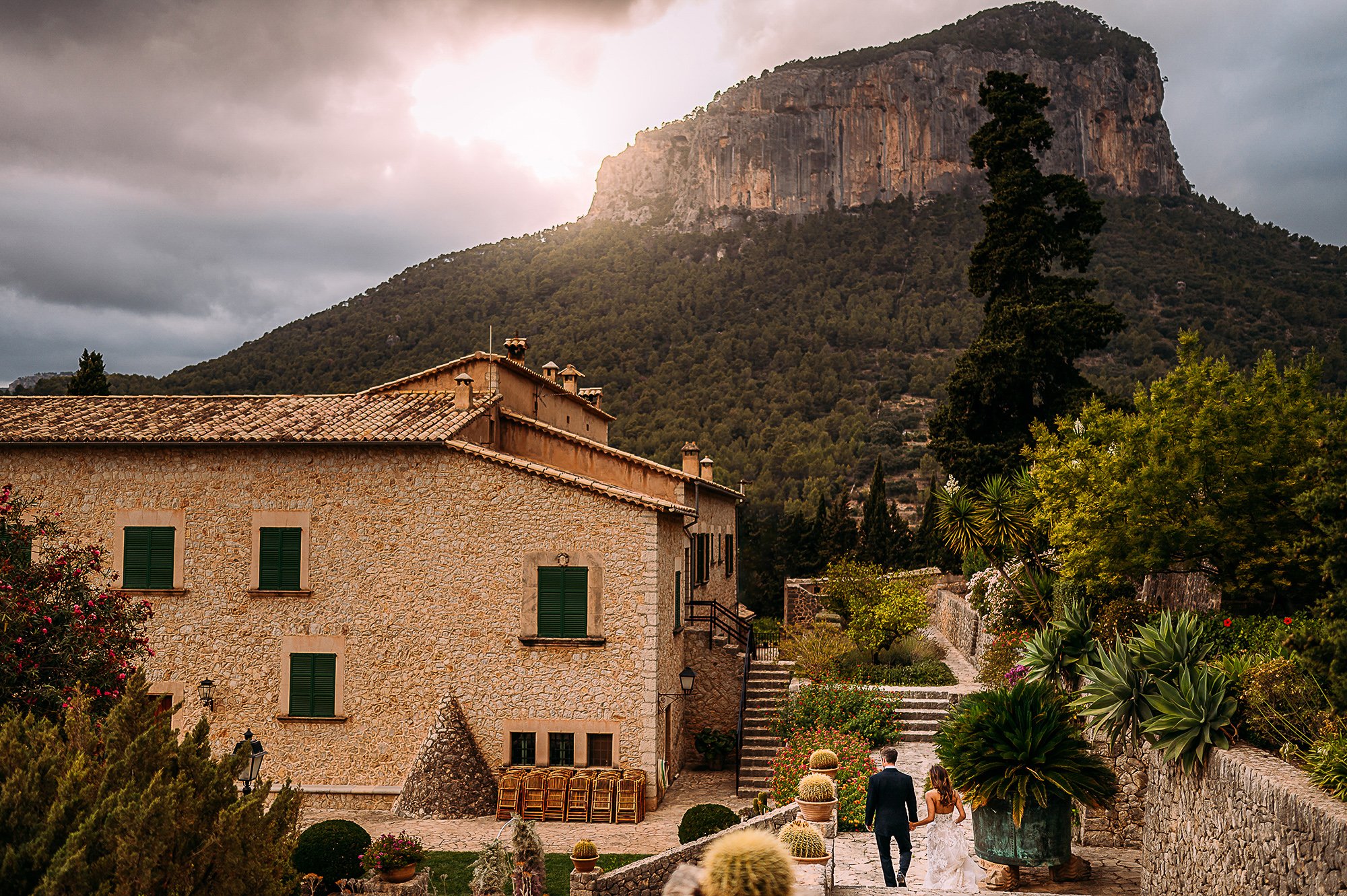  Bride and groom walk to the reception in front of stunning Mallorca scenery 