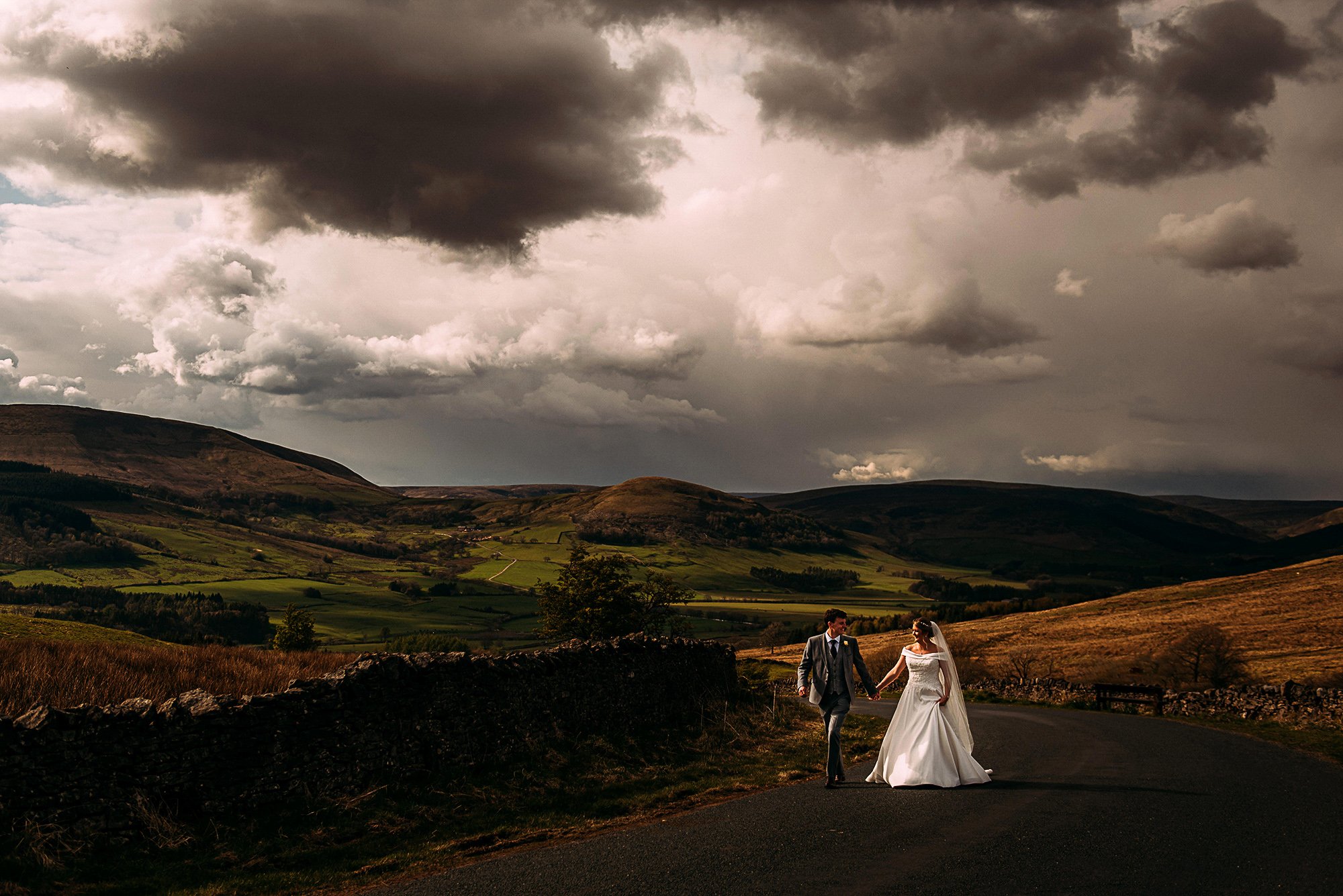  Bride and groom walking along a round at golden hour near Whitewell.  