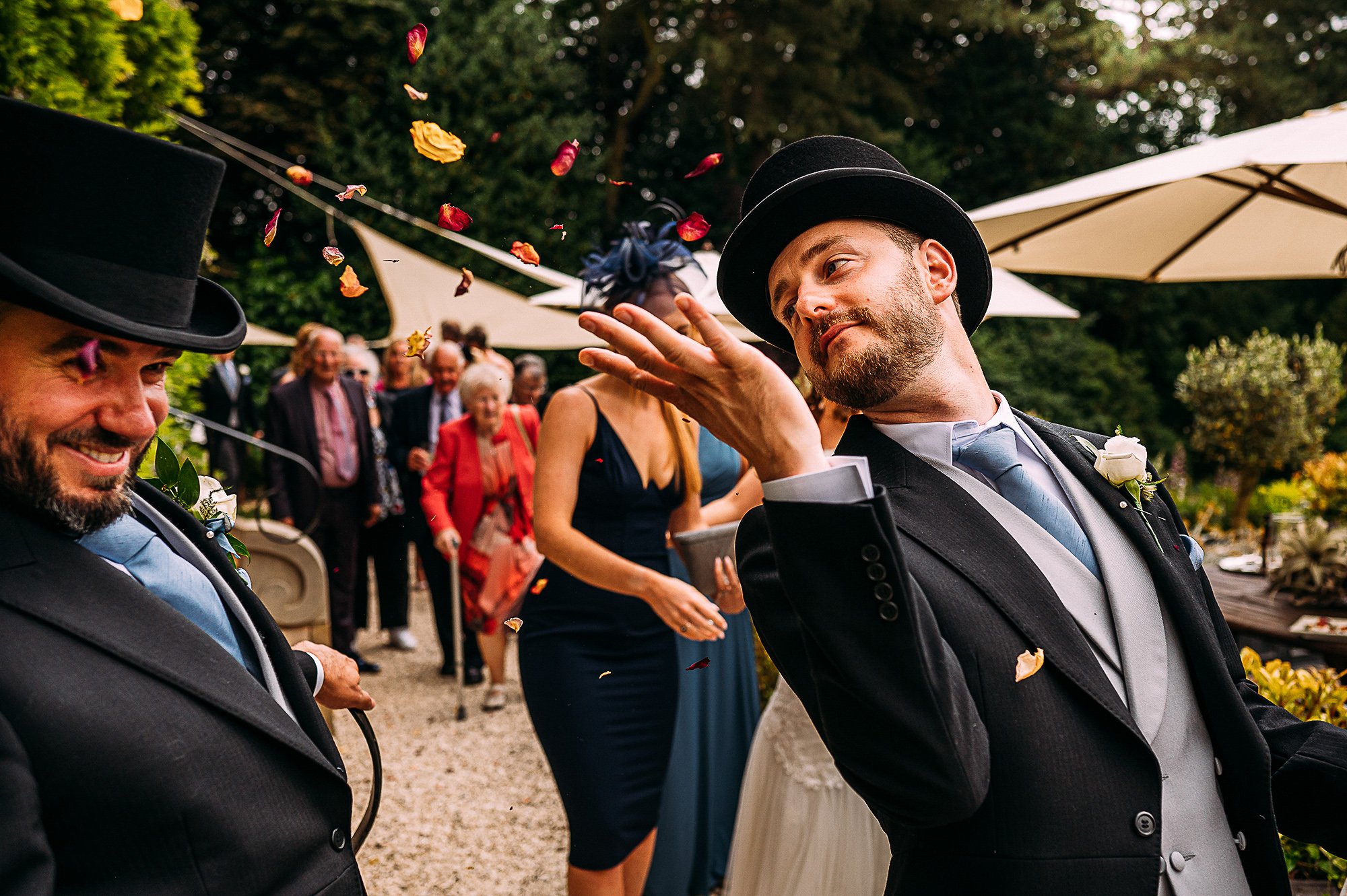  Best man throwing confetti at the groom as he walks past. 