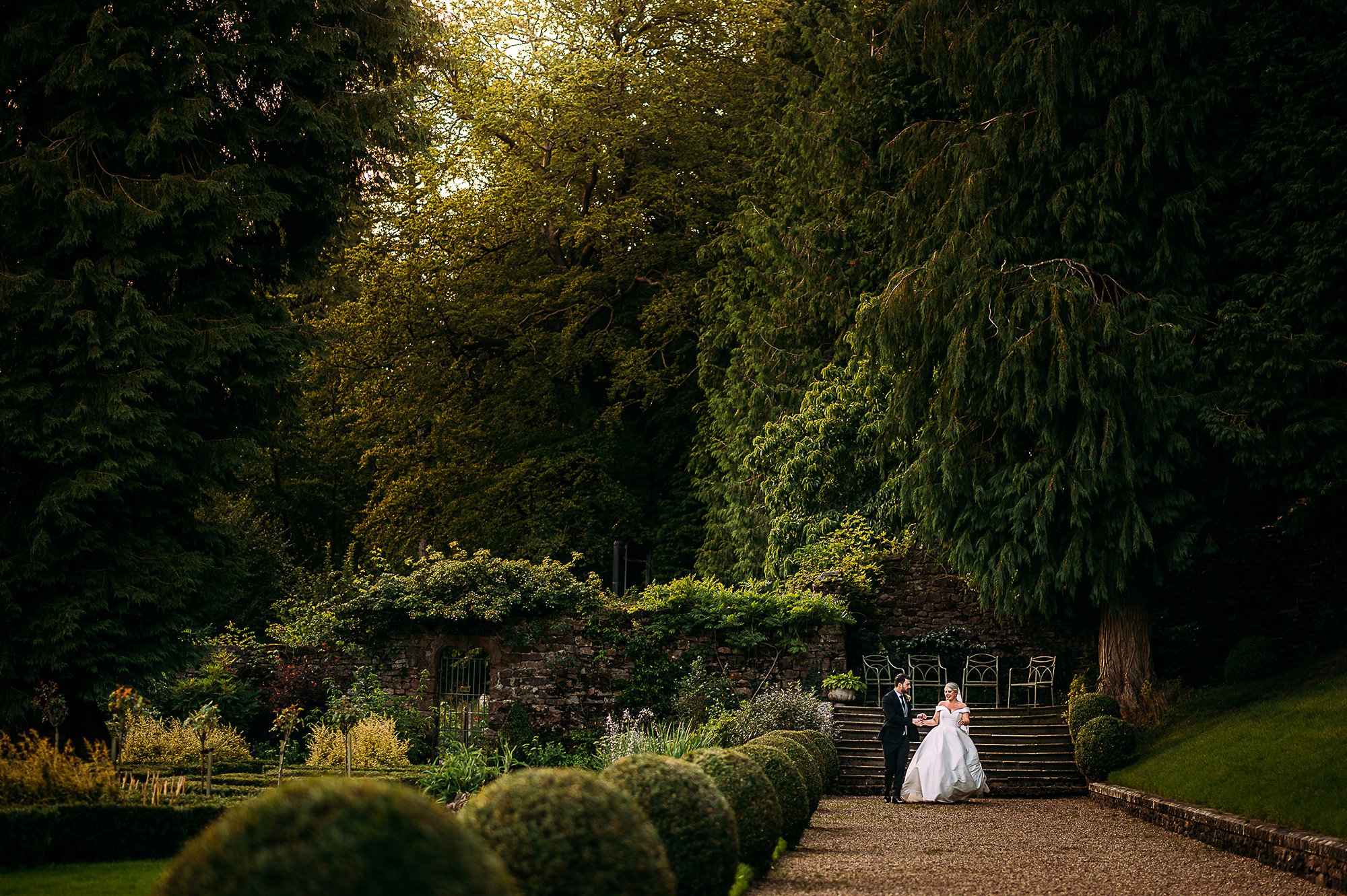  Bride and groom walking through the vast gardens at Browsholme. 