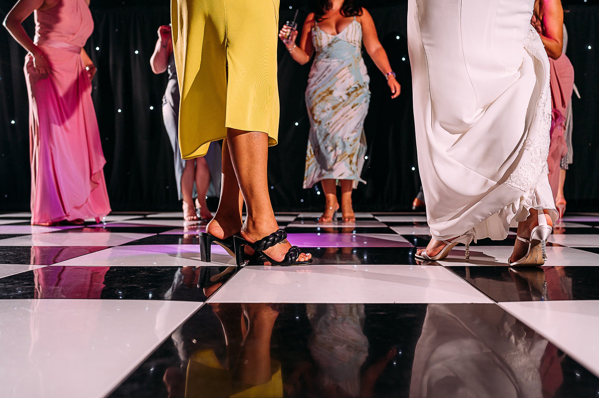  Feet on a chequered dance floor with colourful dresses. 