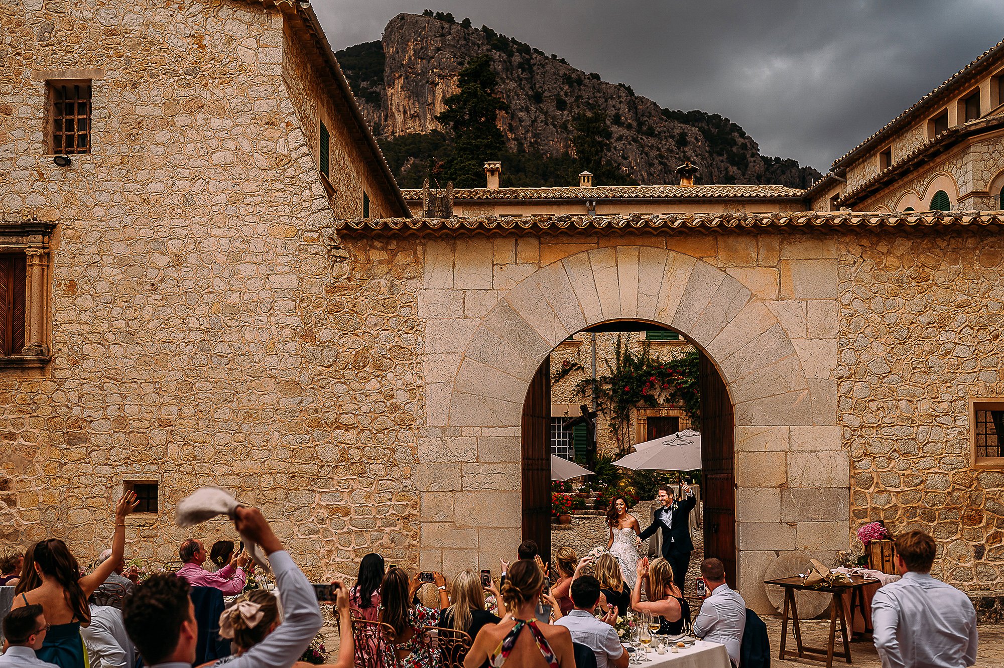  Wide shot of couple entering the wedding breakfast in Mallorca. 