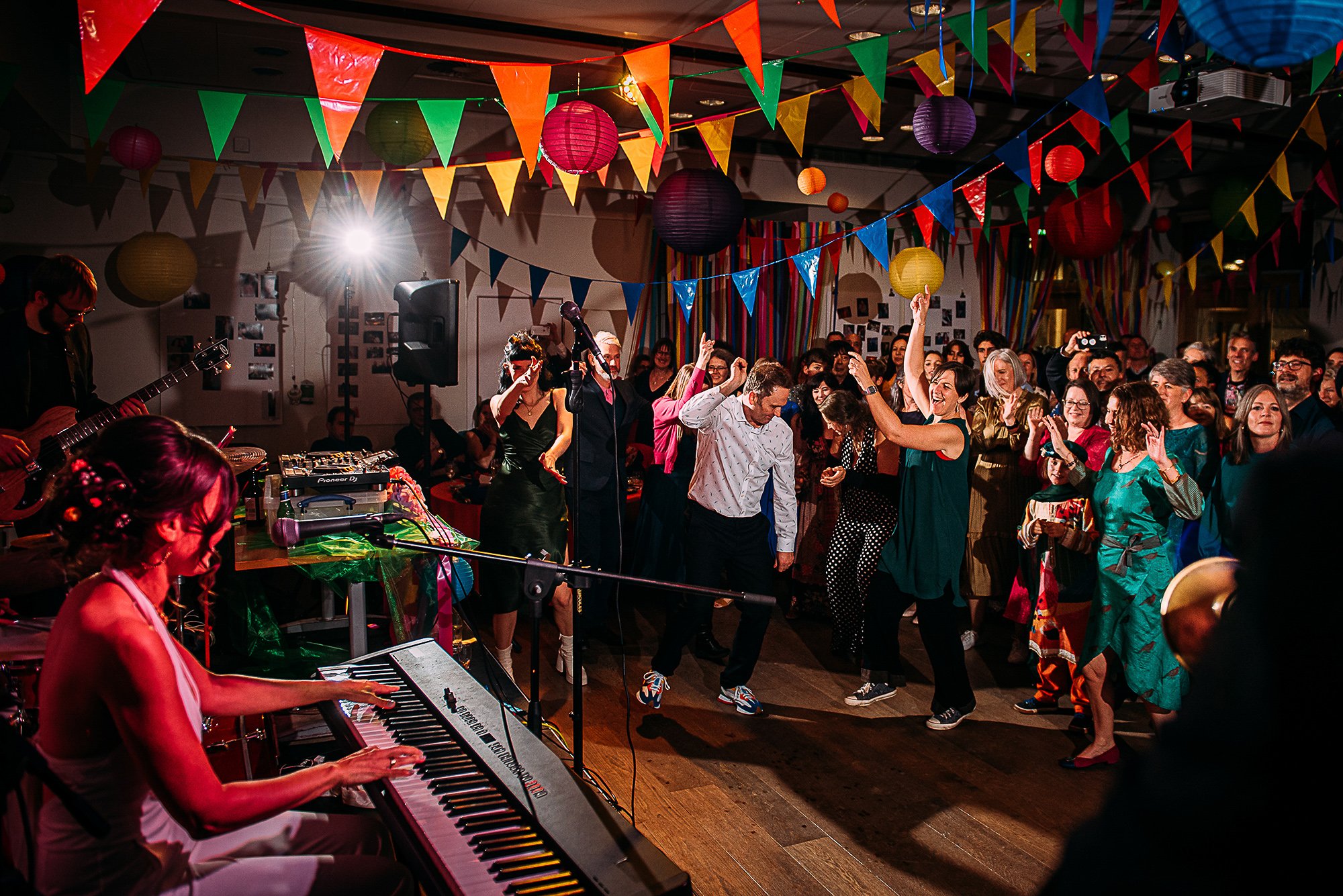  Bride playing a song on the keyboard to her dancing guests. 