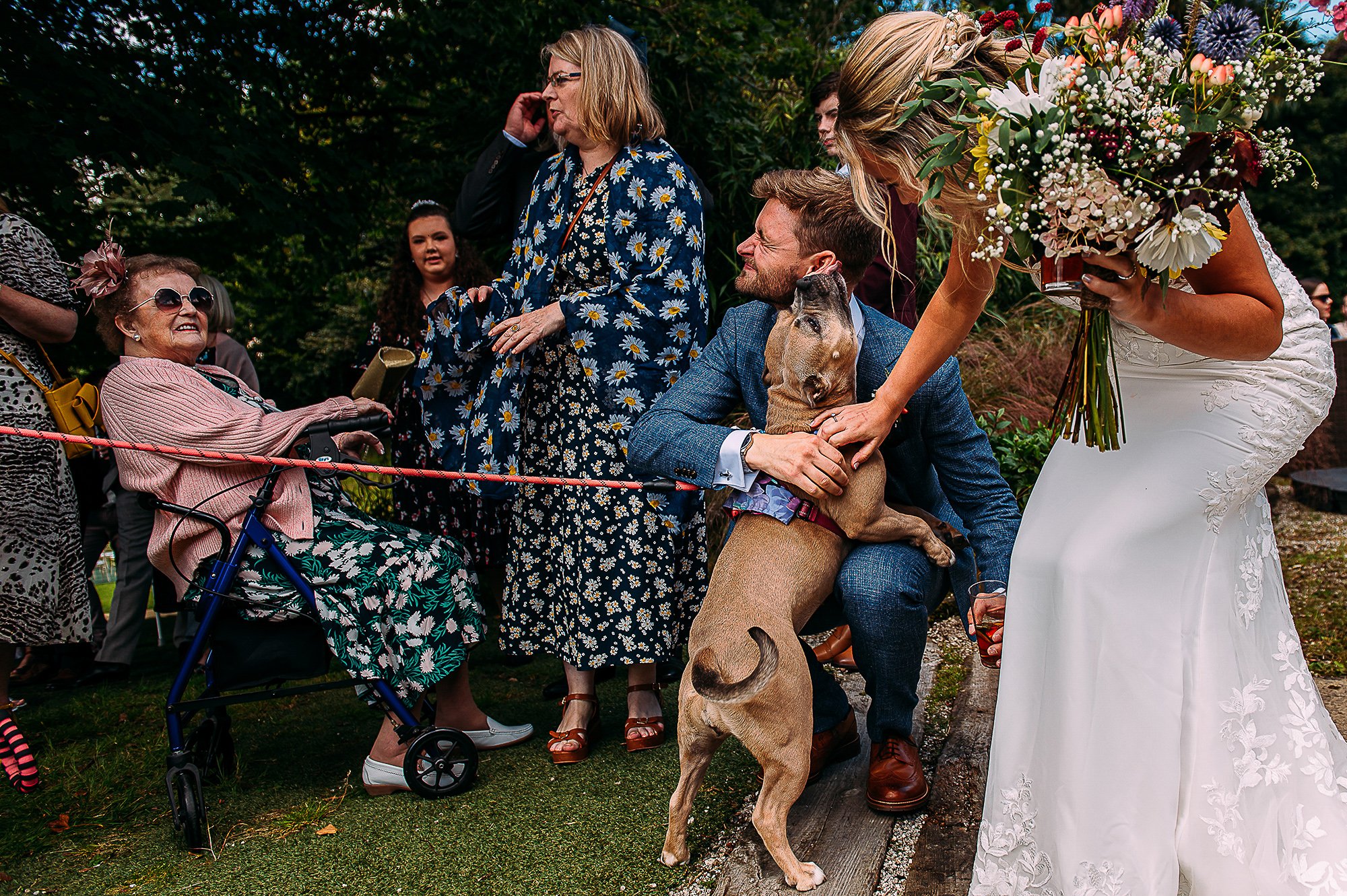  Layered shot with the focus being the groom hugging a dog. 