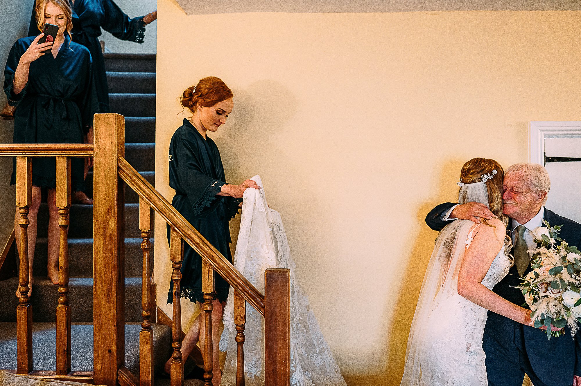  Bride hugging her dad at the bottom of the stairs. 