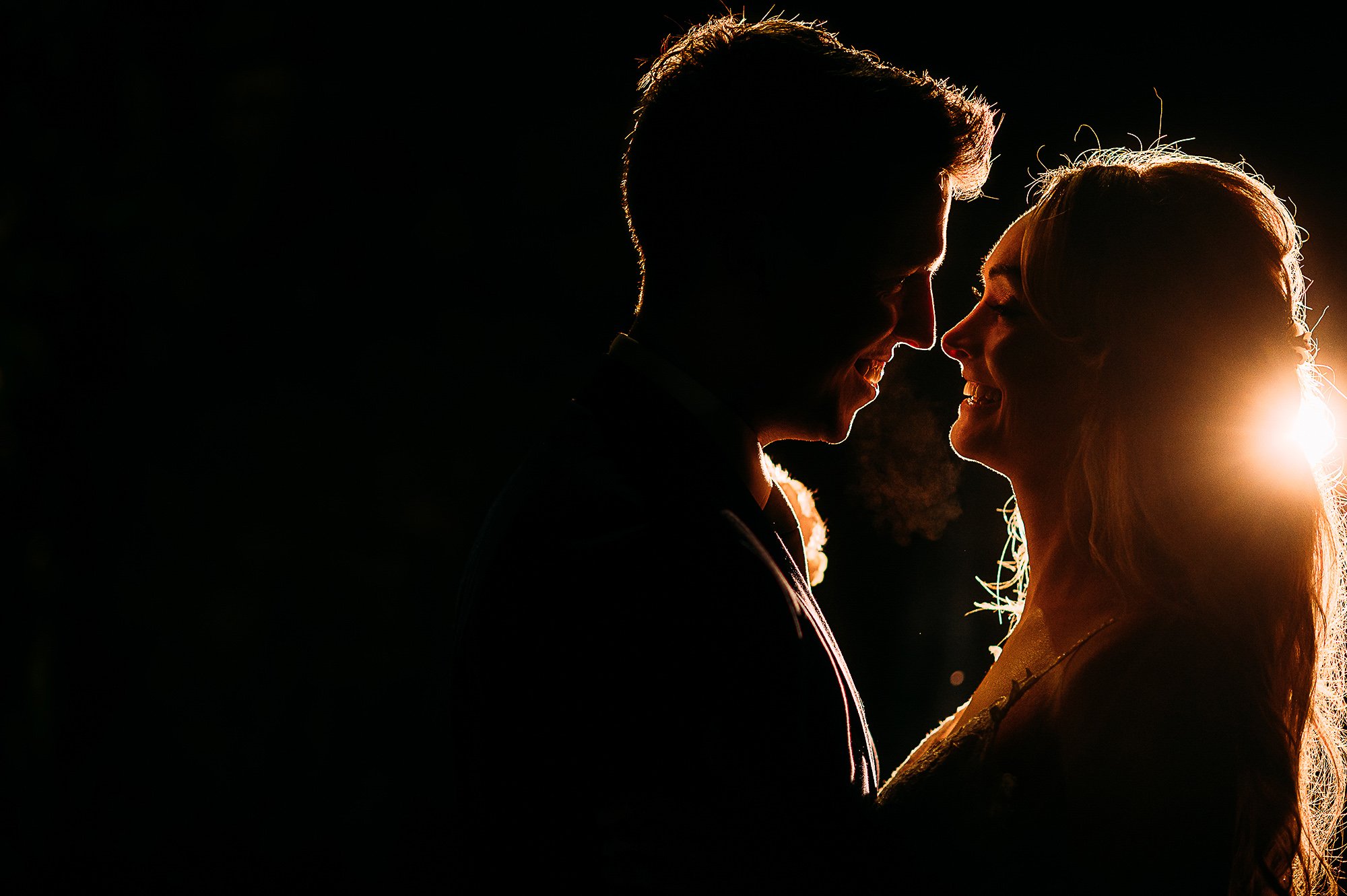  Back lit picture of bride and groom at night. 