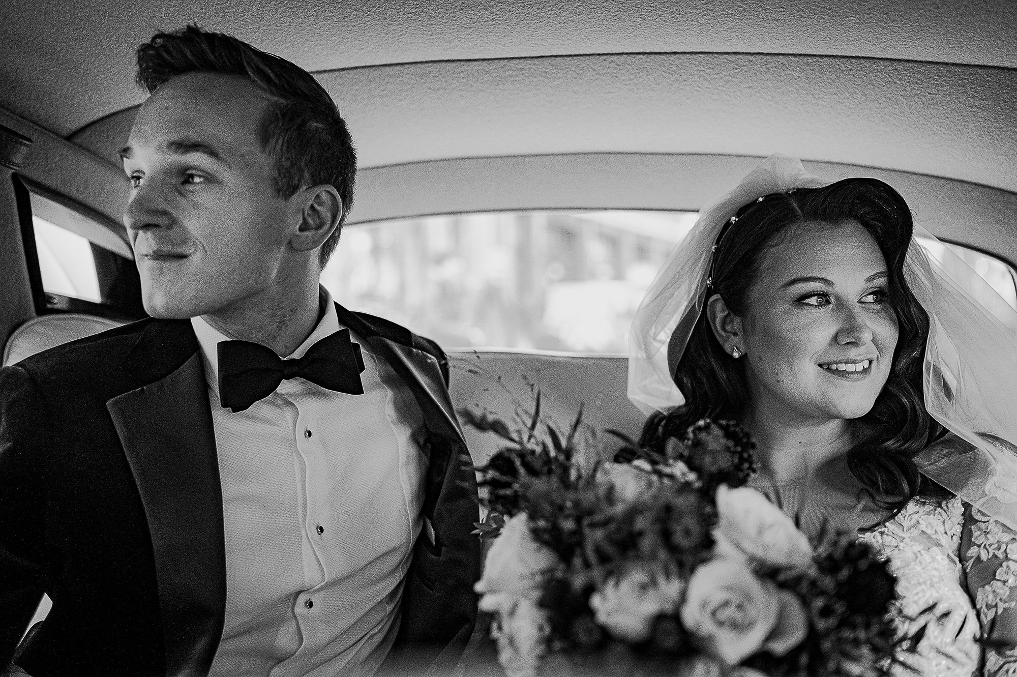  Bride and groom in the back of the wedding car. 