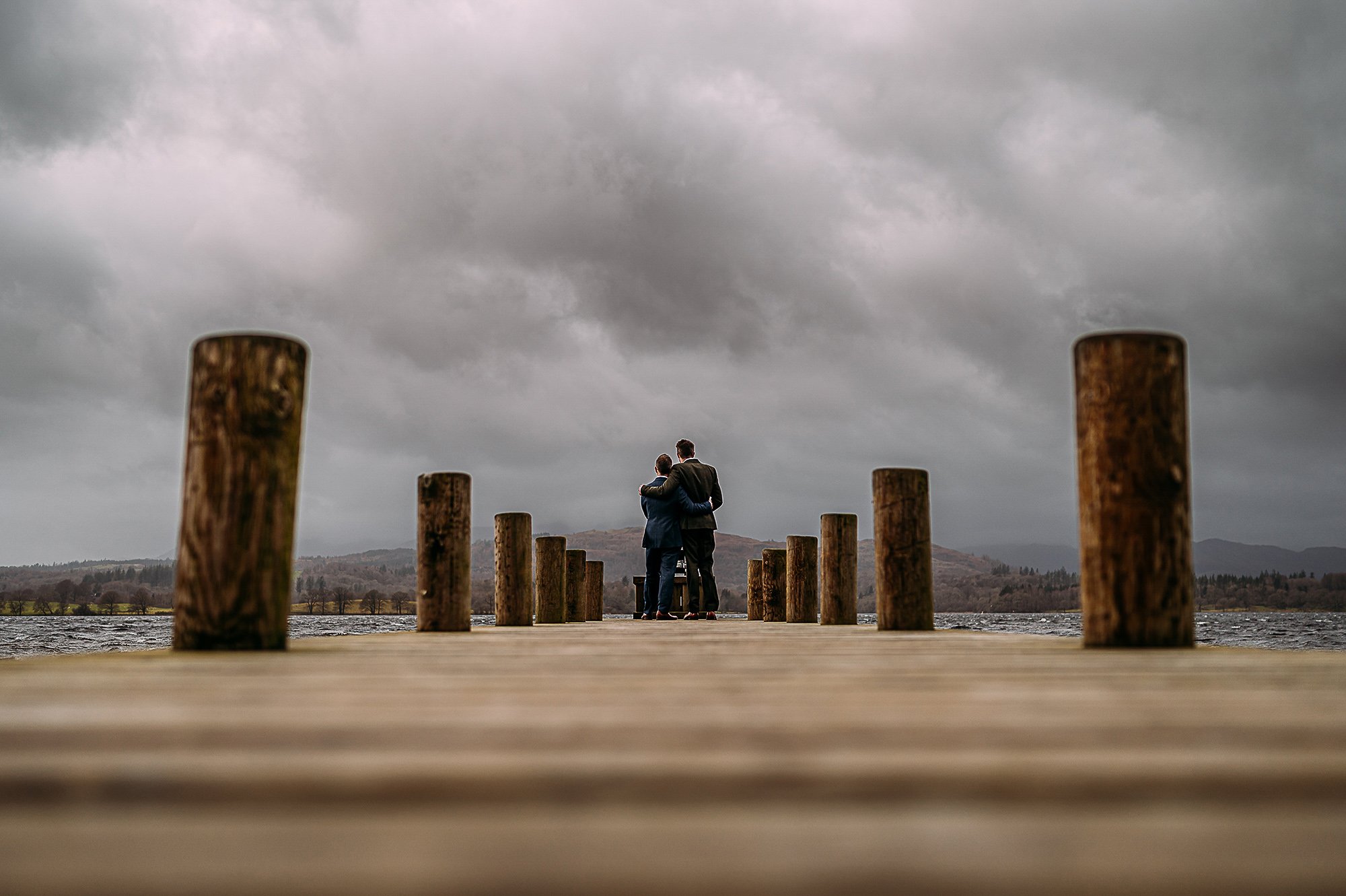  LGBTQ+ couple stood at the end of a jetty on the lakes. 