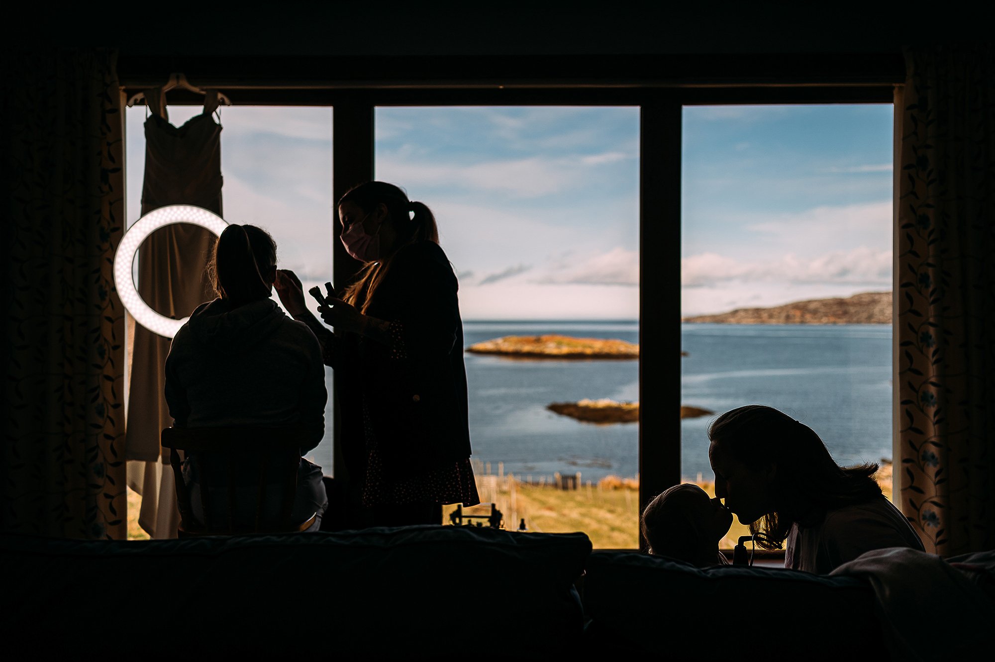  window silhouette of bride and daughter kissing. 