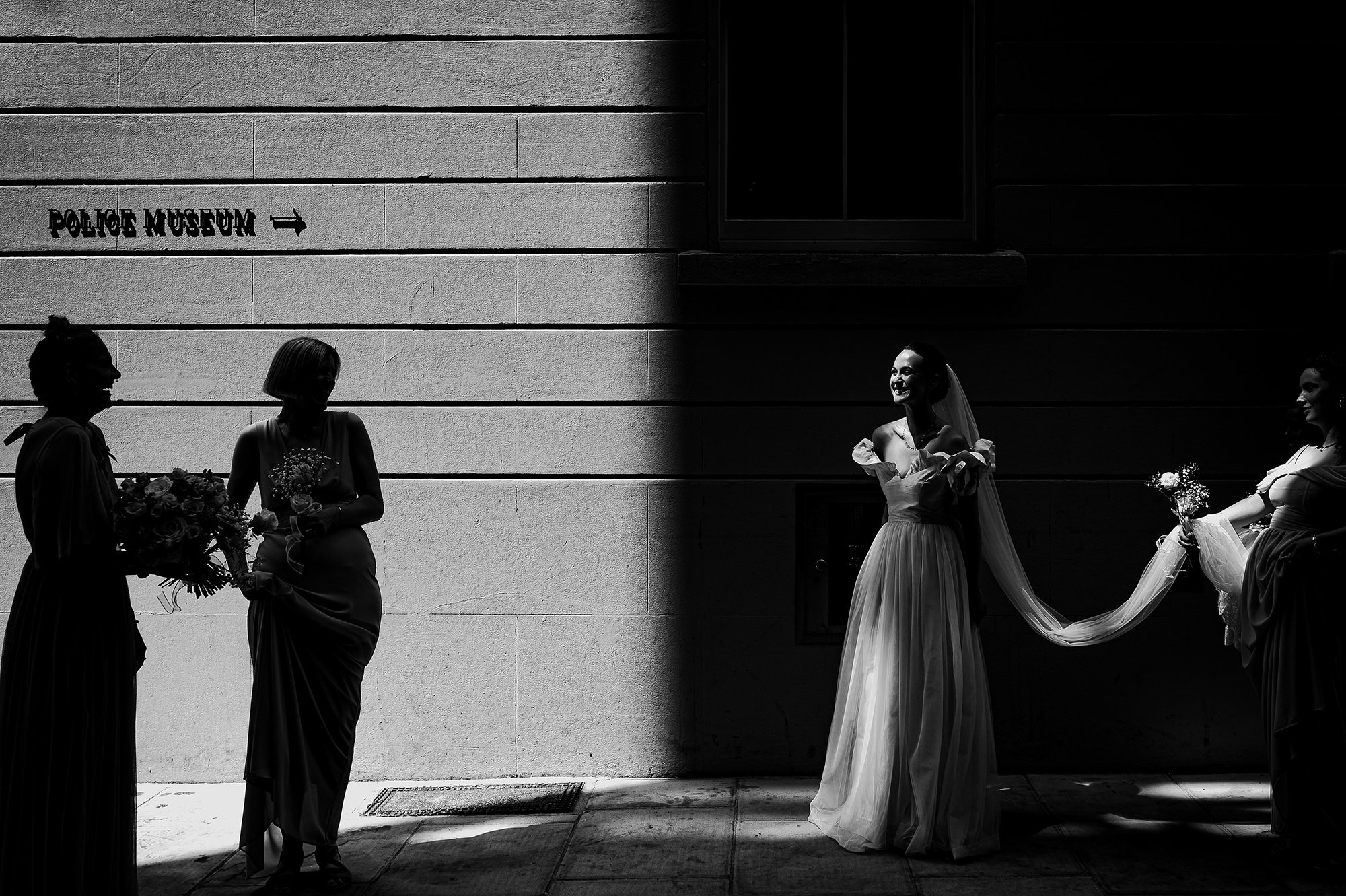  Split light/shadow photo of bride and friends walking to church. 