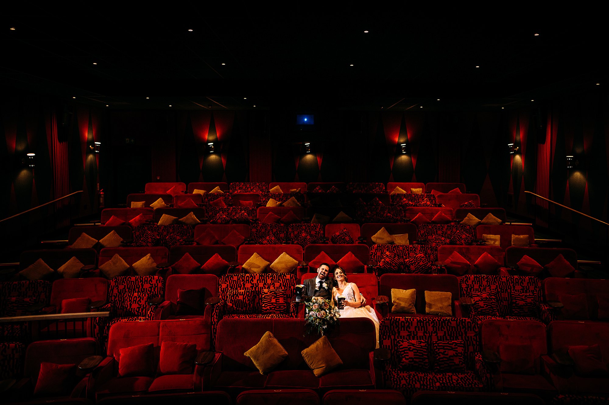  Bride and groom sat in an empty cinema. 
