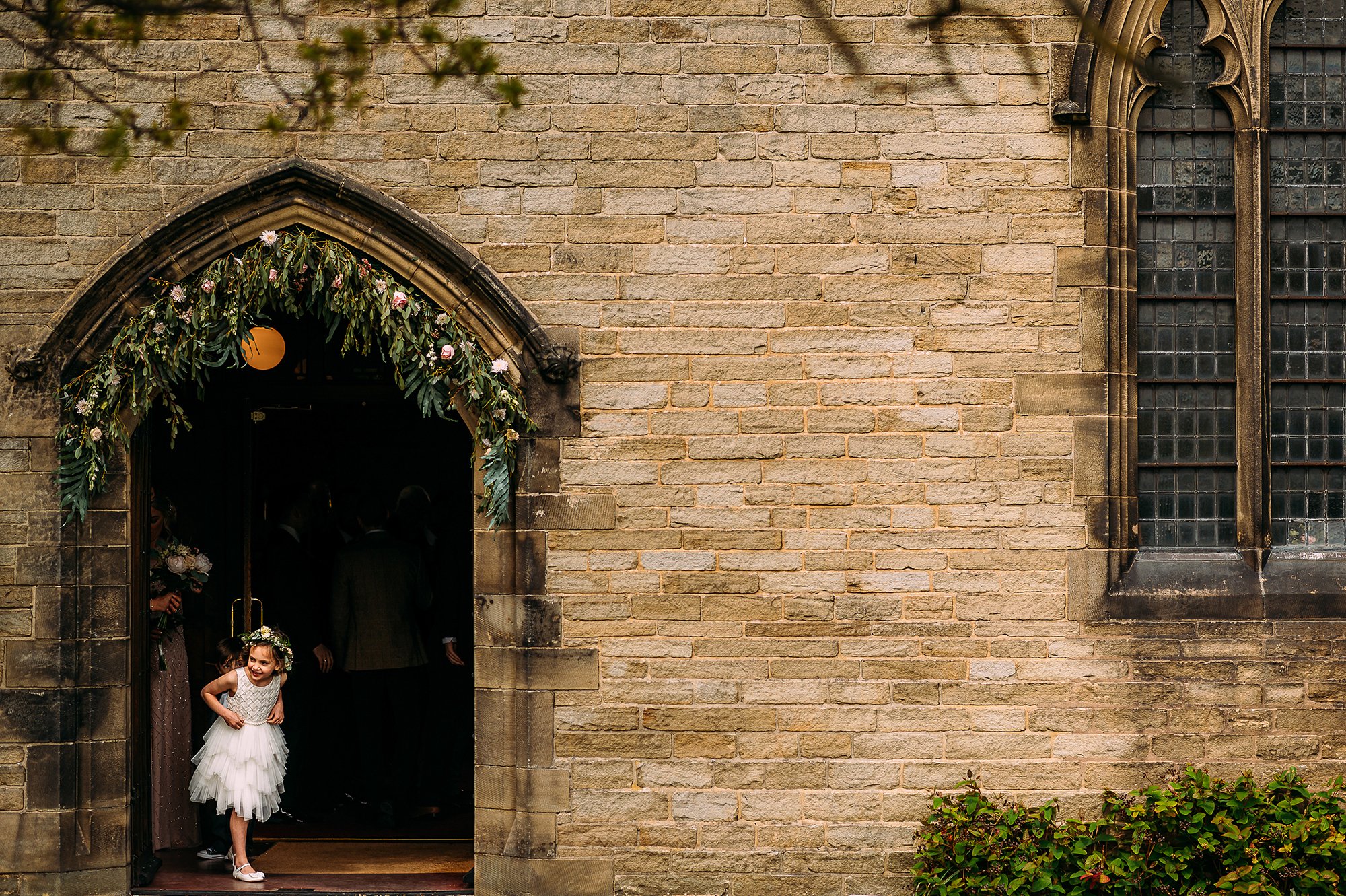  Little girl looking for bride in church door way. 