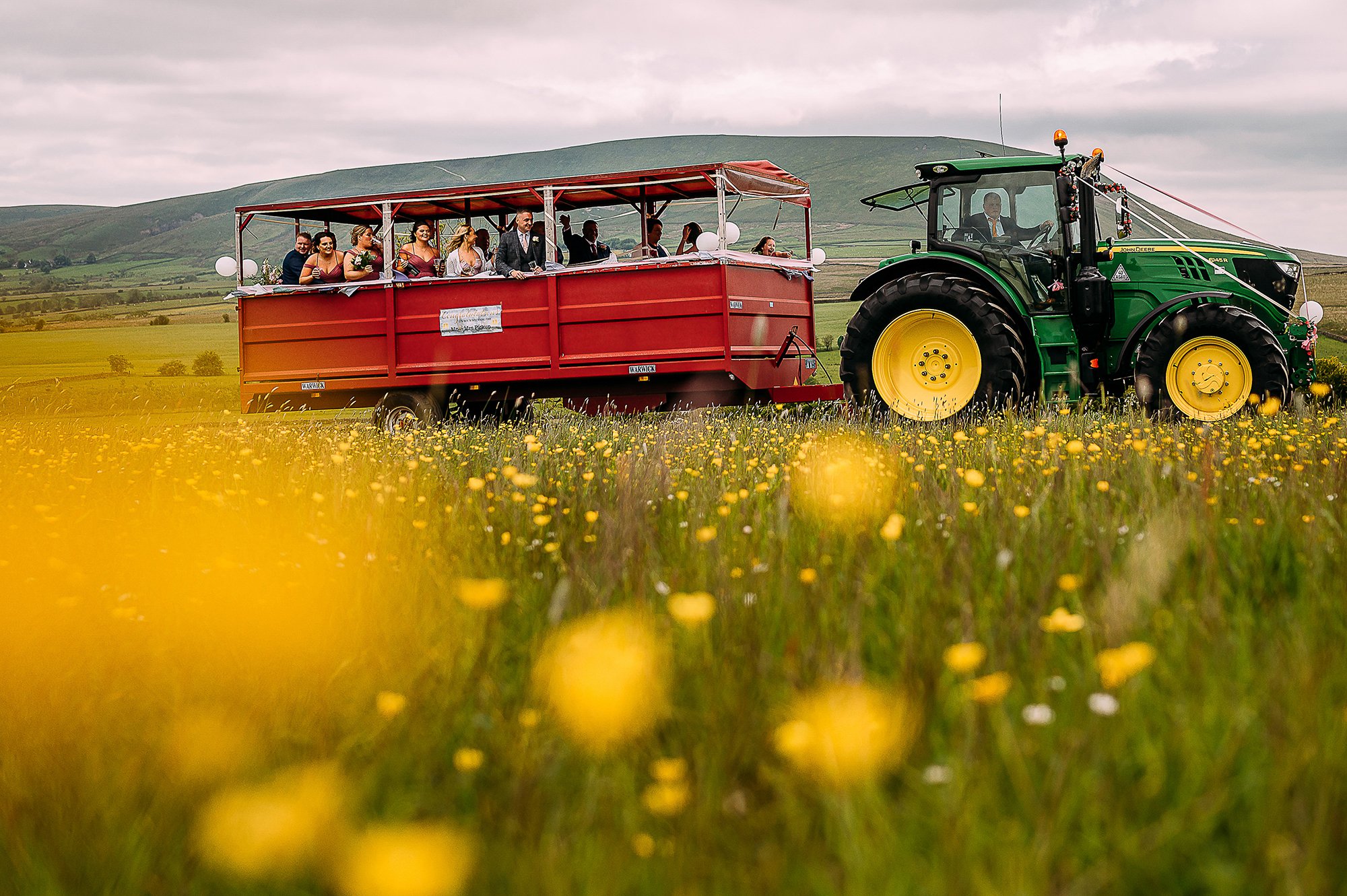  Tractor with yellow wheels mirrored by daffodils bringing guests to reception. 
