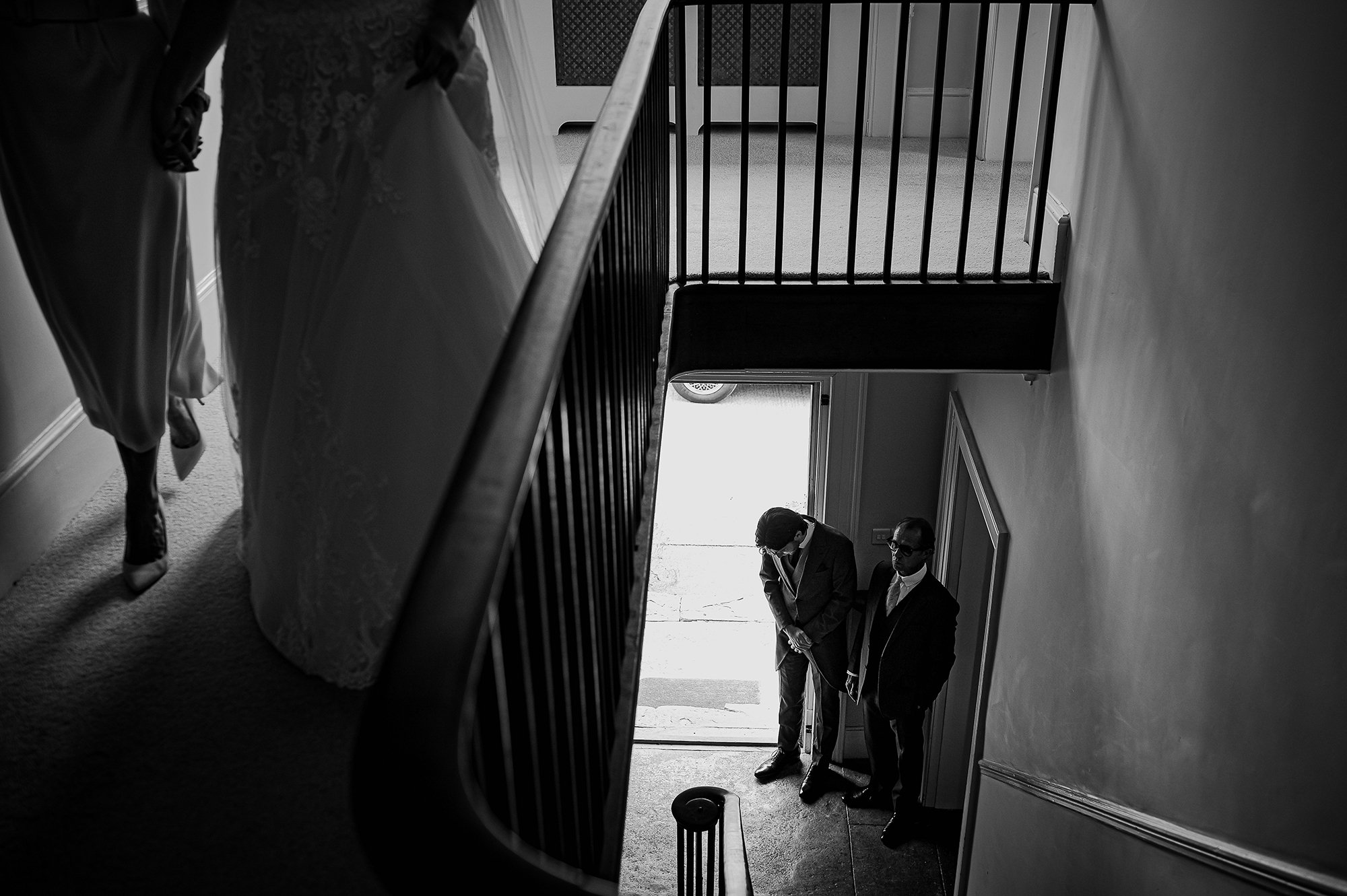  Bride’s father at bottom of stairs with her feet walking towards stairs at the top. 