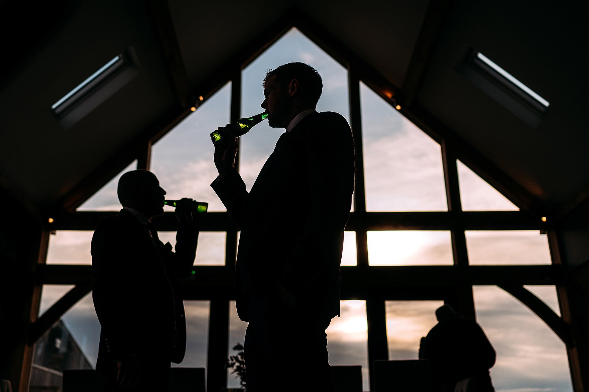  Silhouette of men drinking beer in a cool window. 